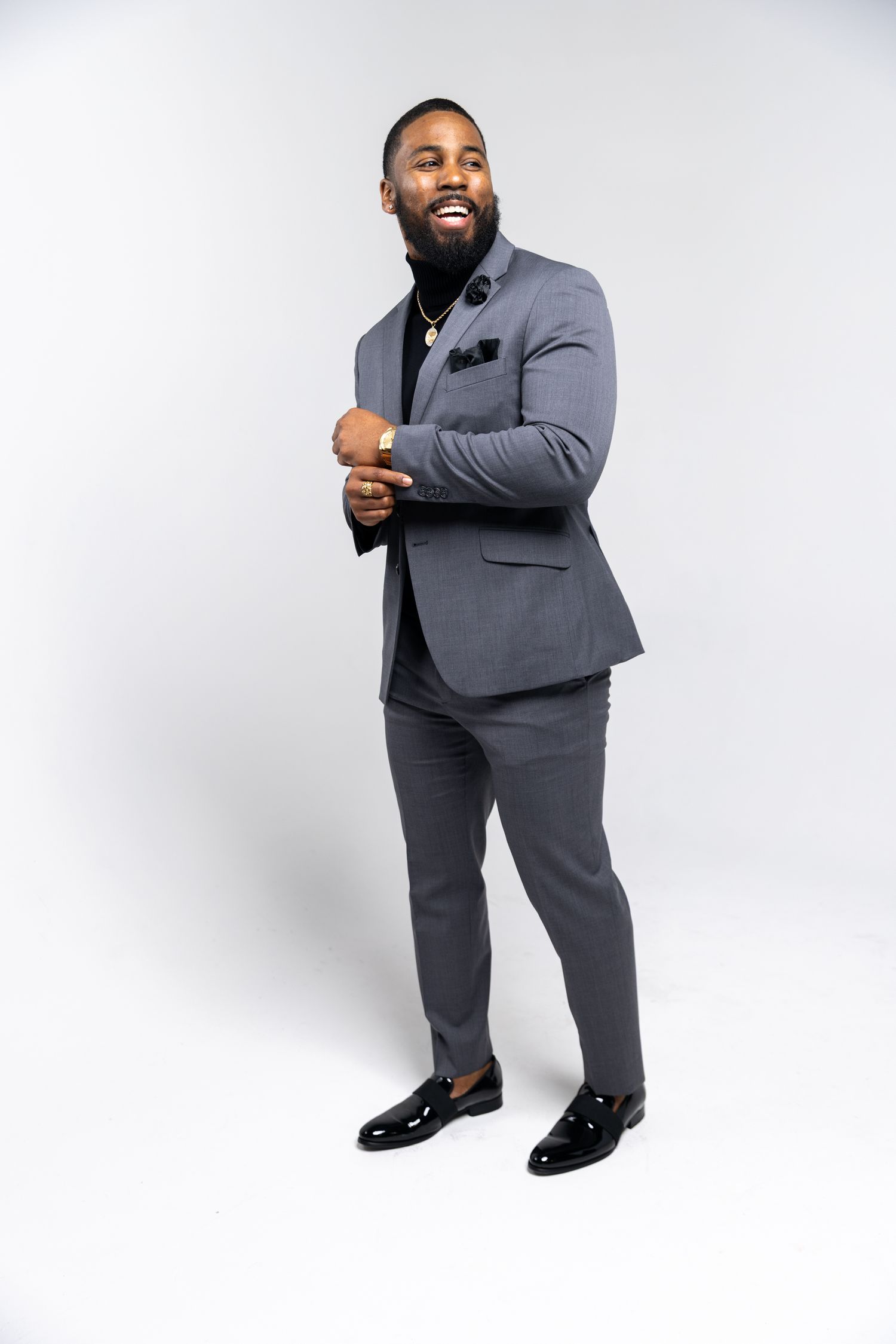 Professional photo of someone in a well-fitted grey suit and dress shoes against a white backdrop.