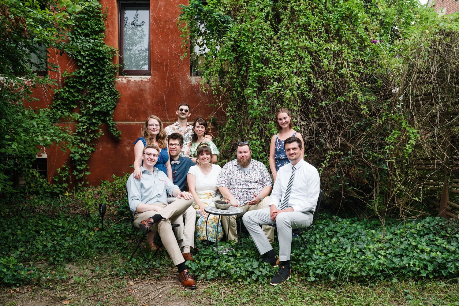Wedding guests sit in a formal setting outside