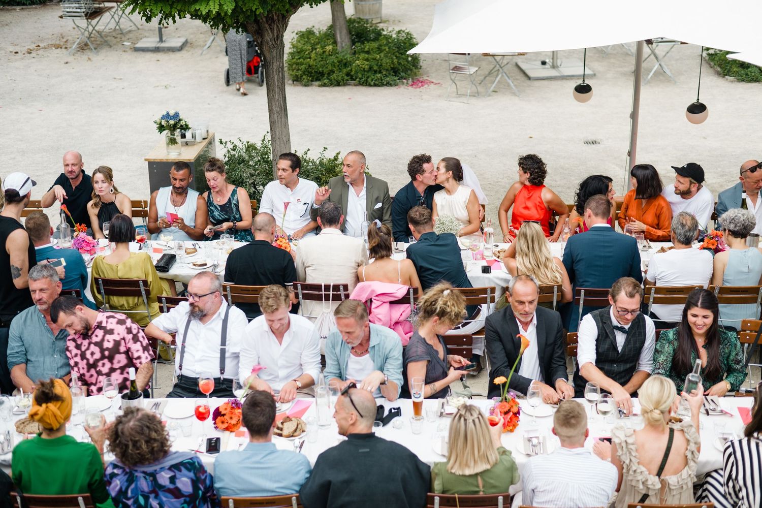 Wedding guests sit down for a meal in the summer in Berlin young