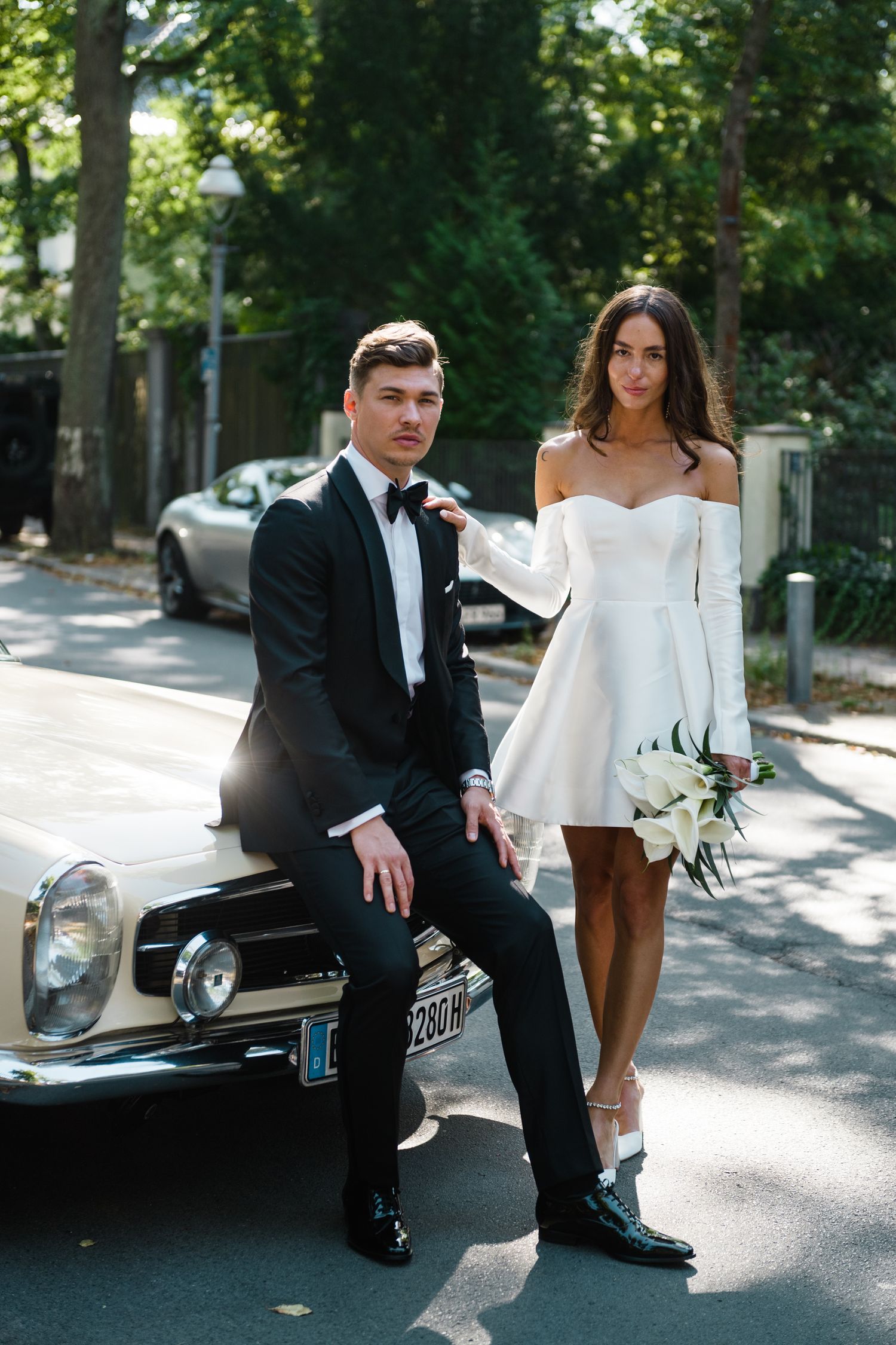 Schönes Hochzeitspaar geht an klassischen Mercedes