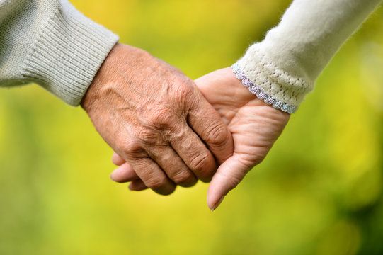 eldery couple honding hands