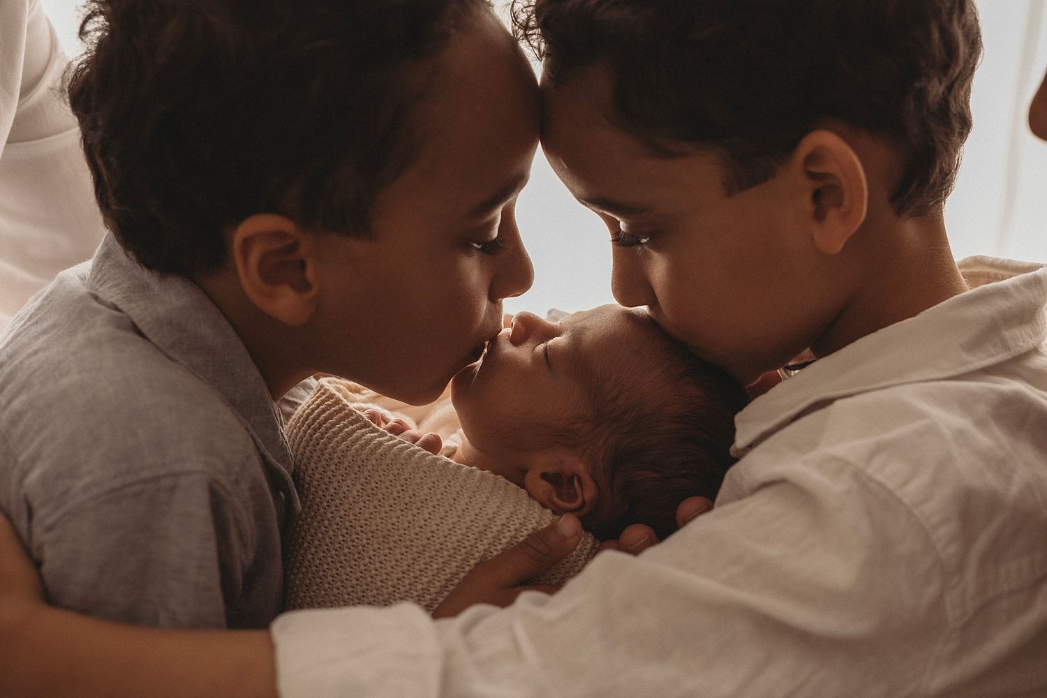 brothers cuddling their new baby brother in geelong photographer studio newborn session