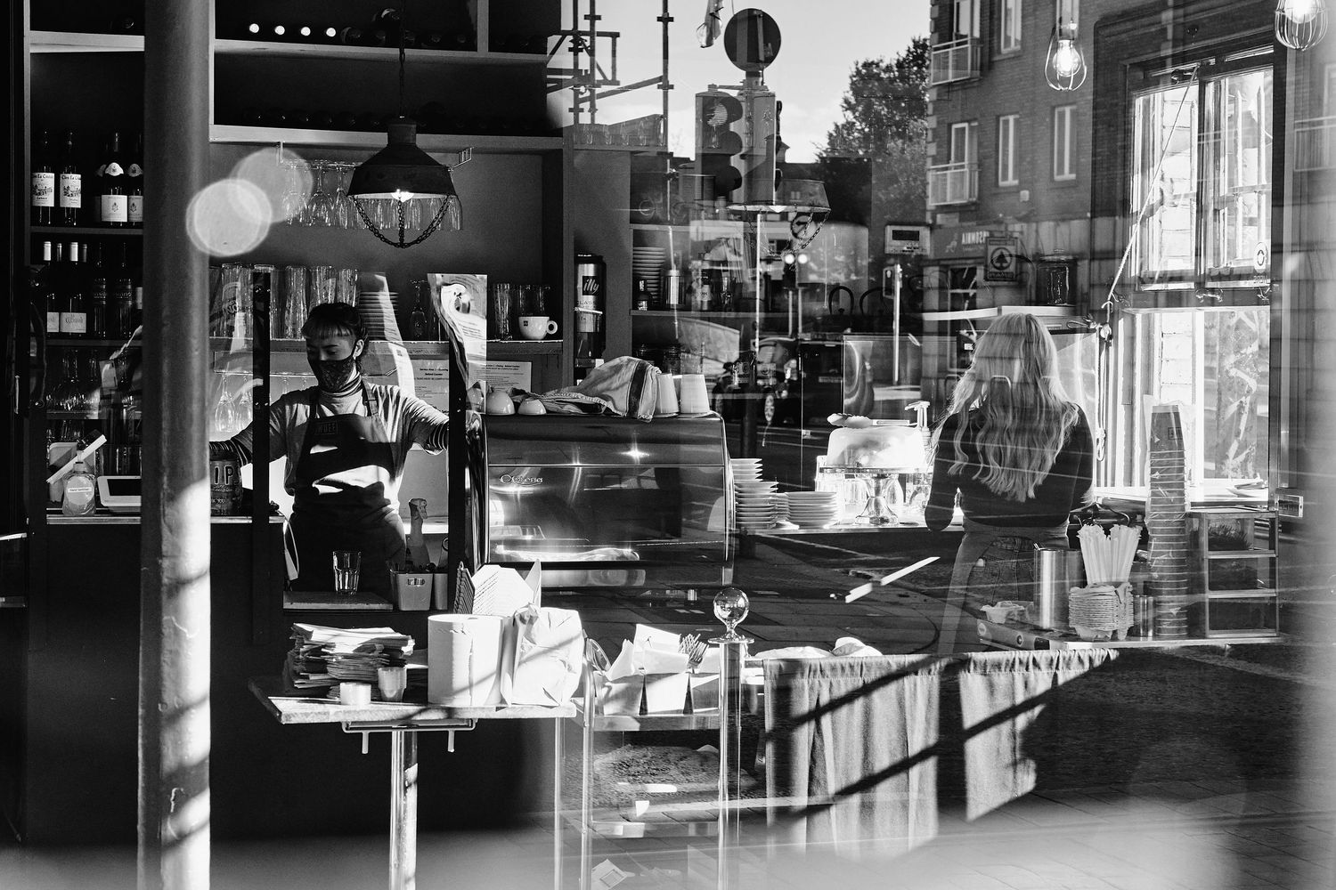A vintage black and white montage of urban street scenes with shops and storefronts.