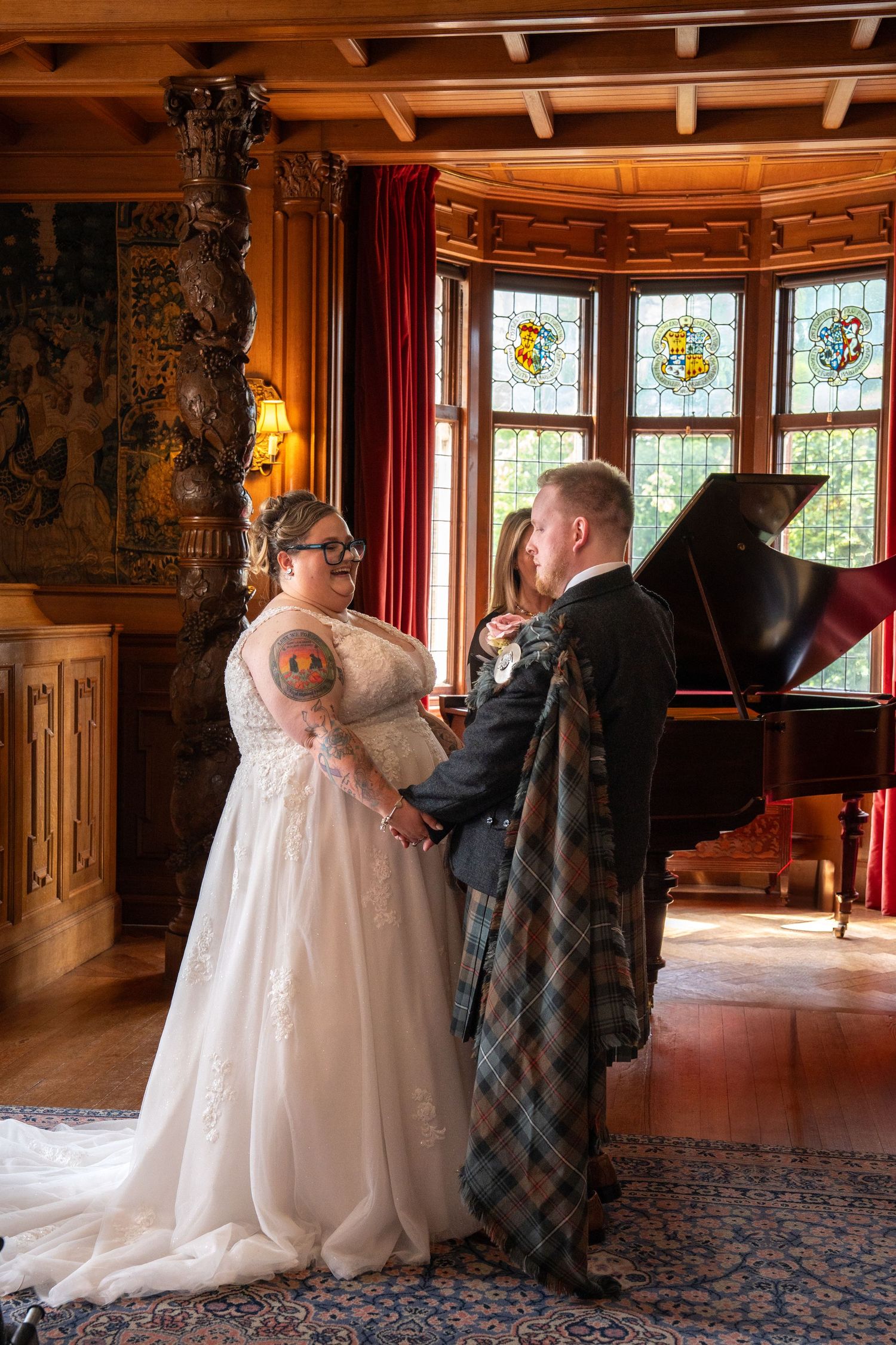 A romantic wedding ceremony in an ornate room with stained glass windows and a grand piano.
