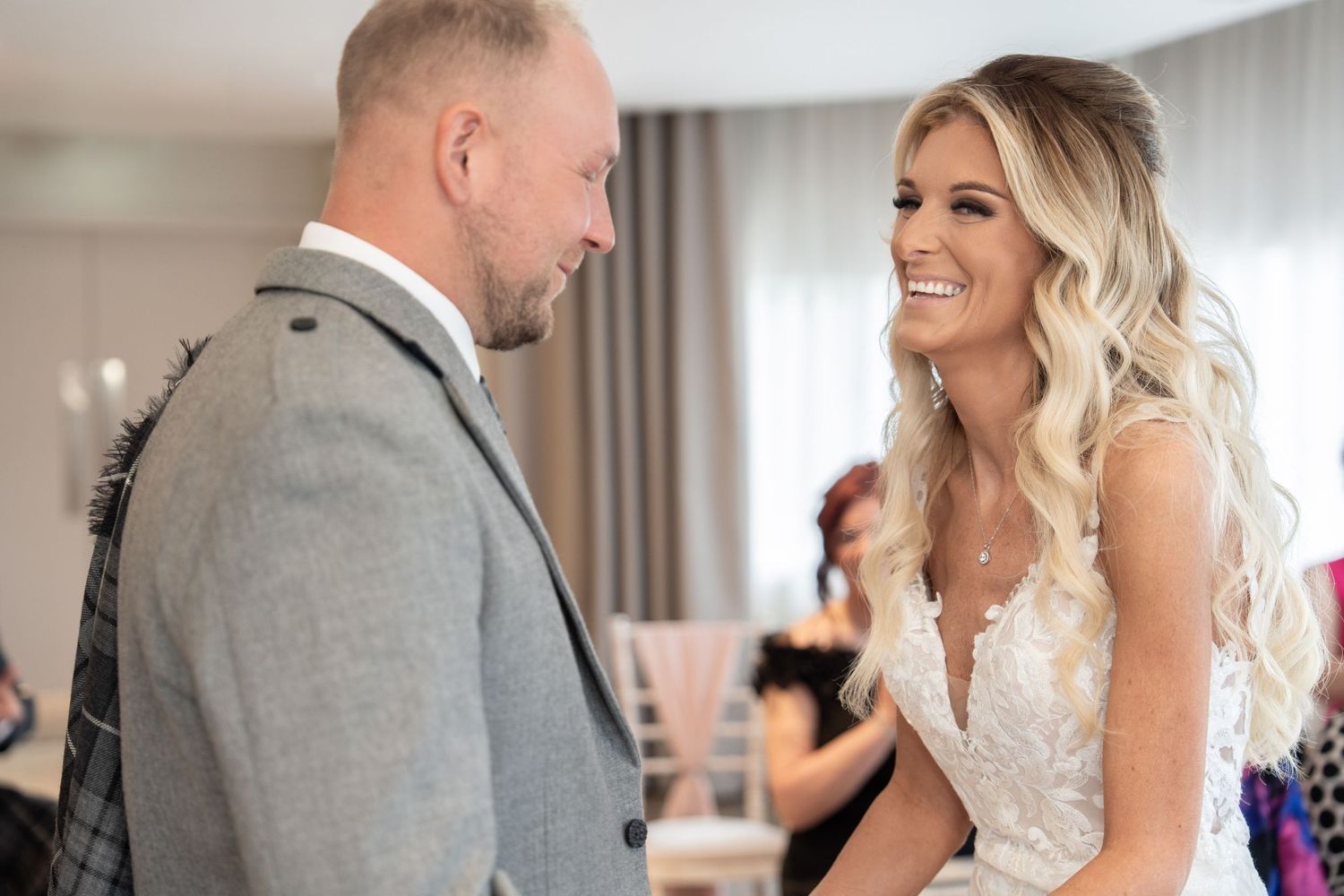 Two people share a heartfelt moment together during what appears to be a first look at their wedding ceremony.