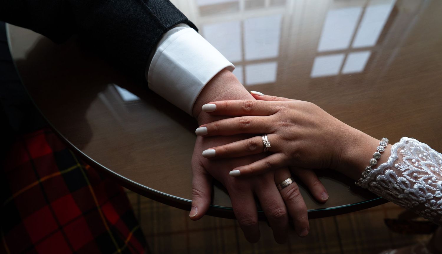 Hands of different people join together in a circular formation showing unity and teamwork.