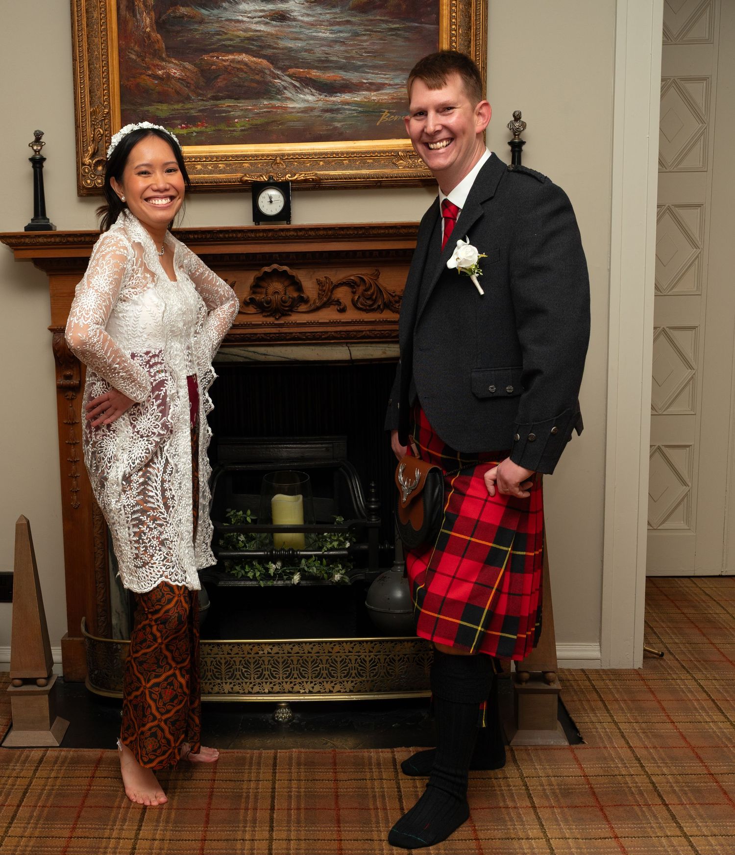 Wedding photoshoot featuring bride and groom in Scottish attire with tartan kilt by an ornate fireplace.
