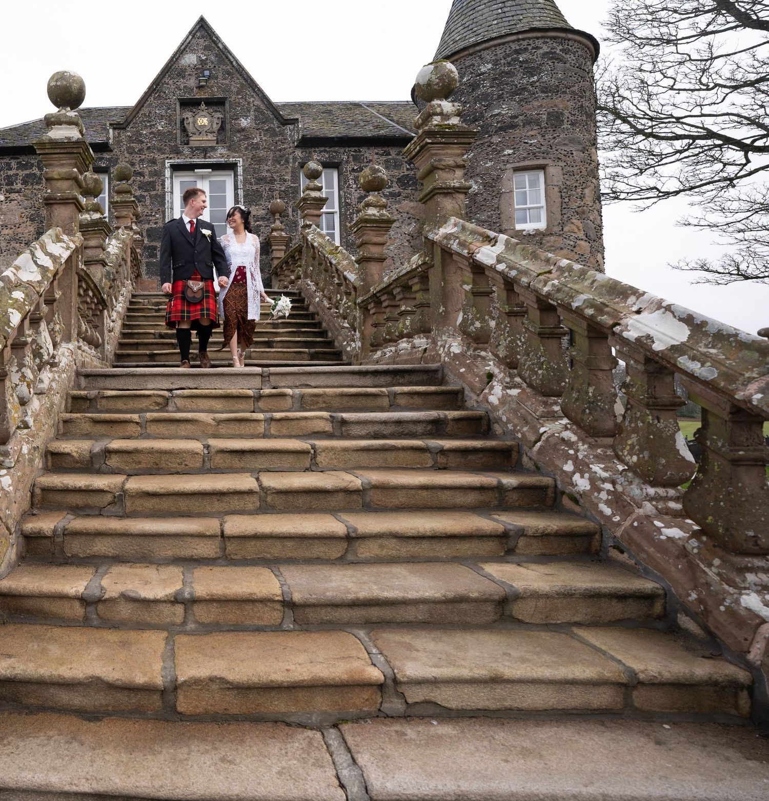 Stone staircase leading up to a historic castle entrance with ornate railings and architectural details.