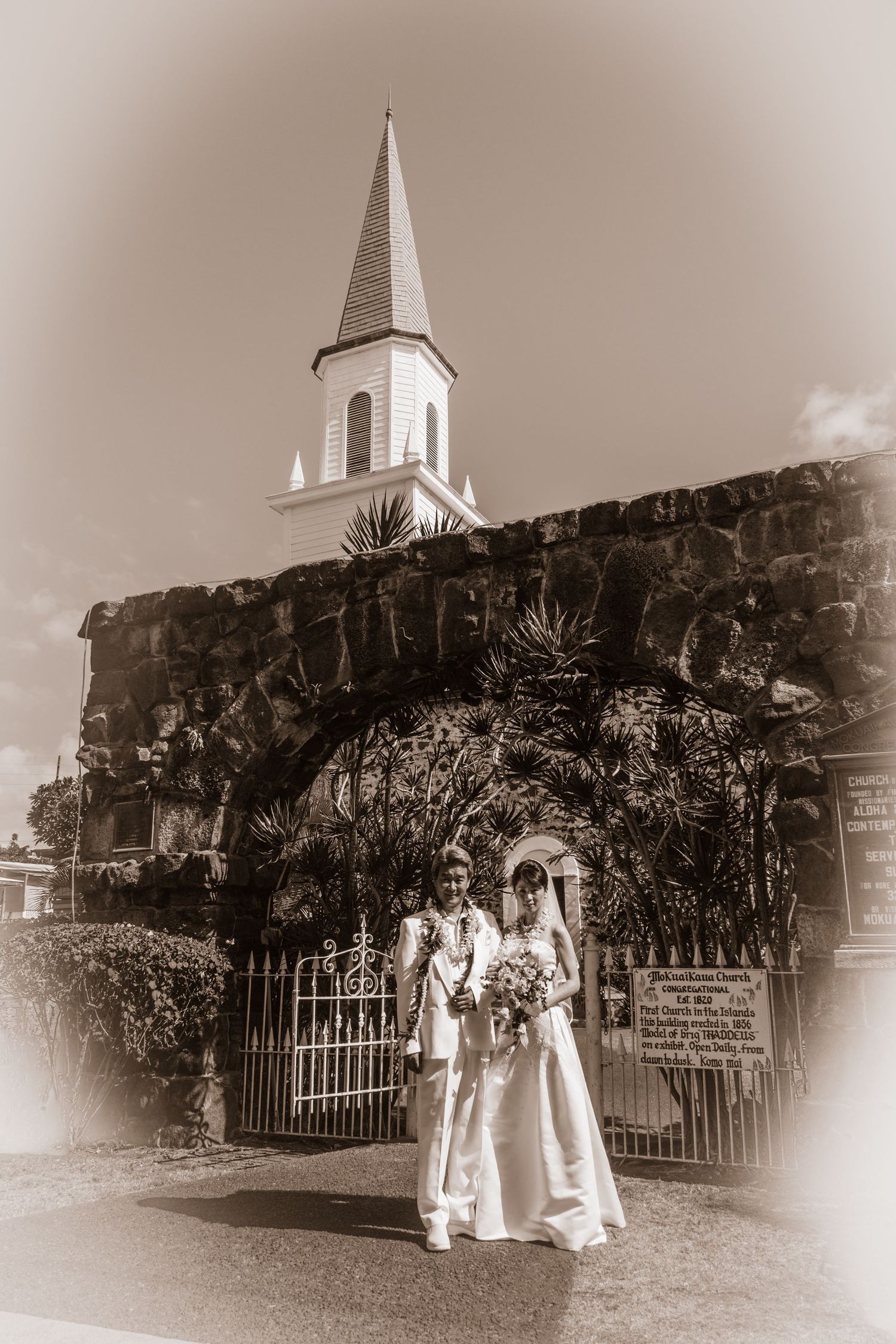 Vintage style photo of a couple in front of the Mokuaikaua church in Kailua Kona downtown.