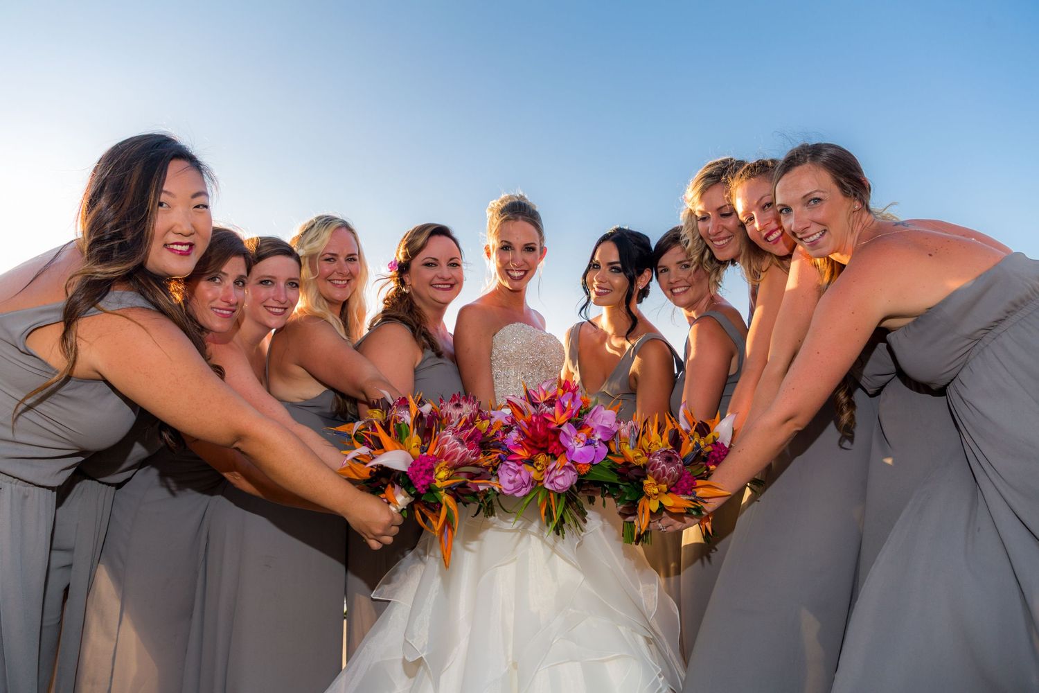 A sequence of candid joyful wedding party photos on a sunny day with grey and pink color scheme.
