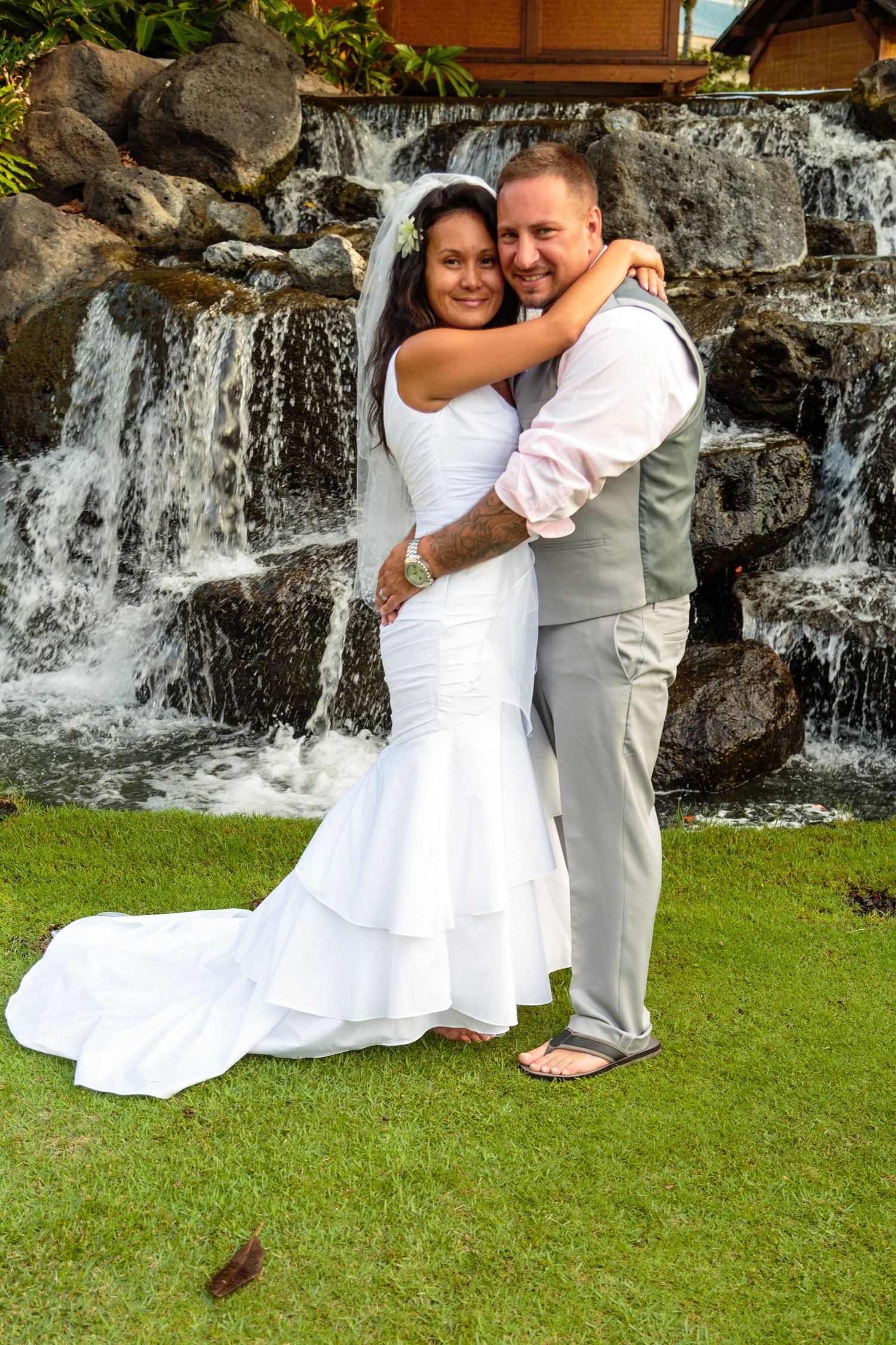 Wedding couple in front of a waterfall at the Fairmont Orchid hotel in Waikoloa, Hawaii.