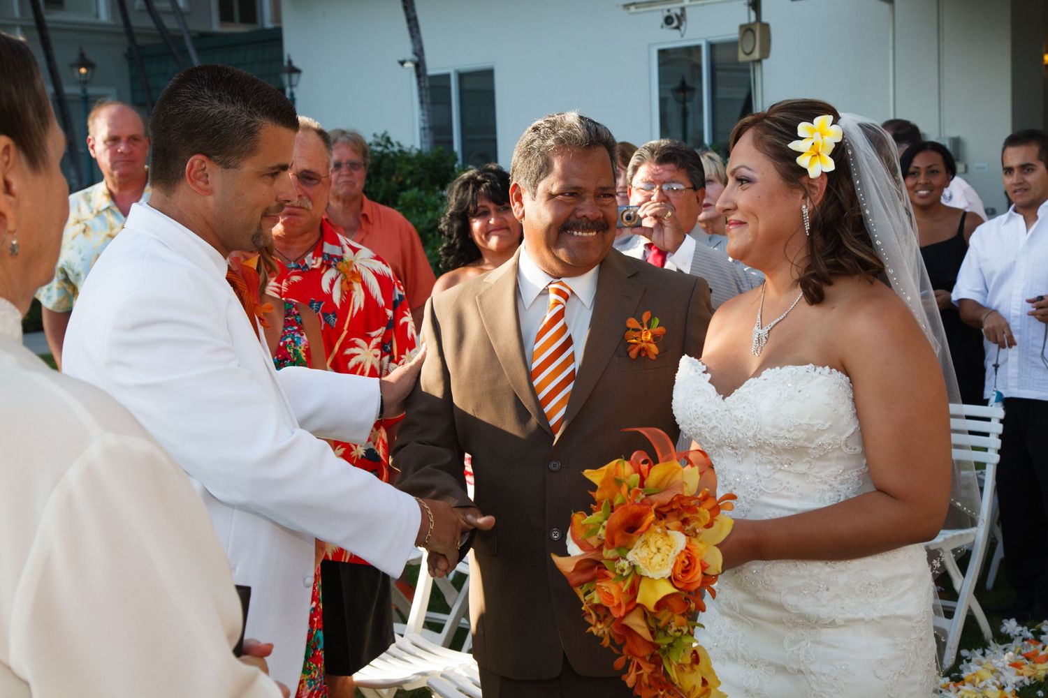 In Honolulu, at the Moana Surfrider hotel of Waikiki, the father of the bride gives the bride away to the groom in a wedding ceremony.