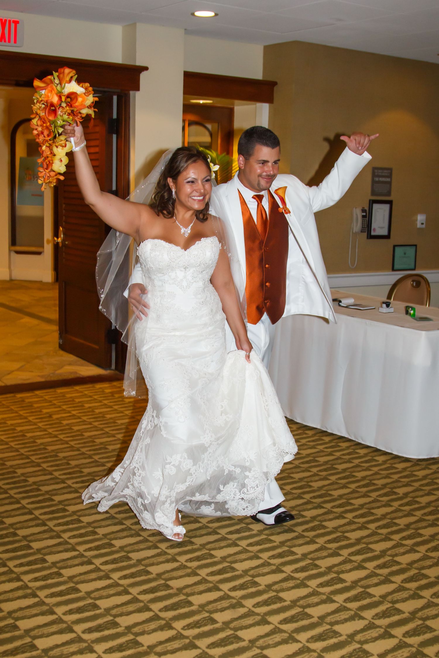 Newlyweds make grand entrance at reception with celebratory dance moves at the Moana Surfrider hotel in Honolulu, Hawaii.