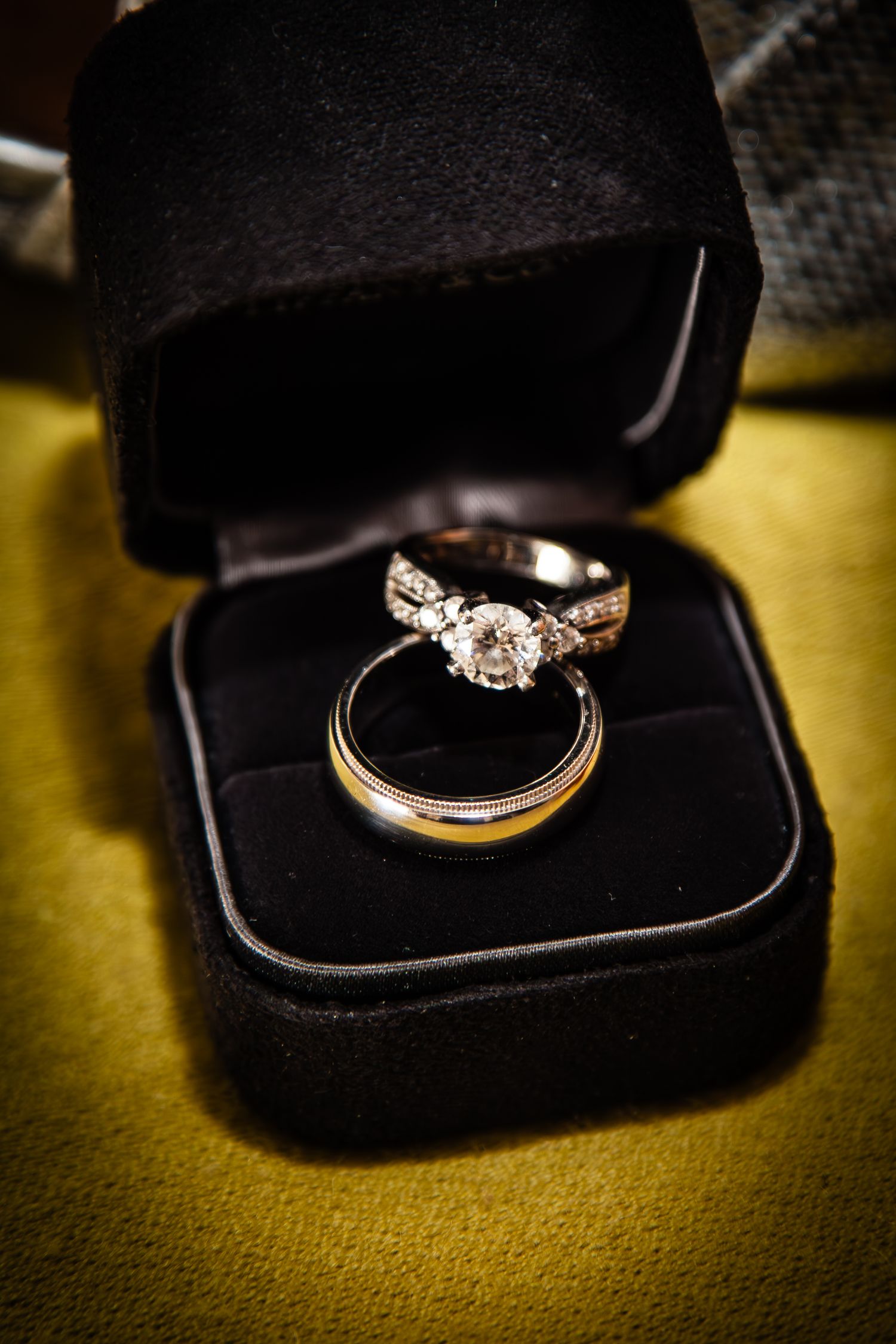 Diamond engagement ring and wedding band nestled in a black velvet jewelry box.
