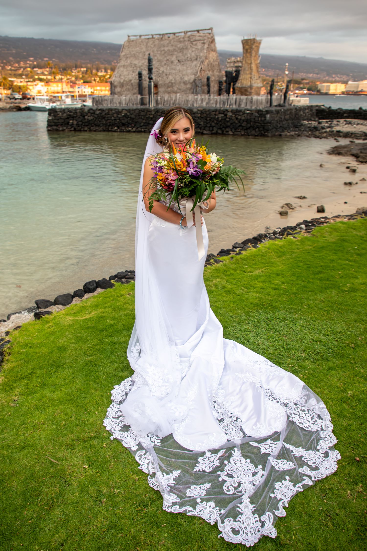 Portrait of a bride holding a colorful bouquet at a wedding at the Courtyard King Kamehameha's Kona Beach Hotel in Kailua-Kona, Hawaii.