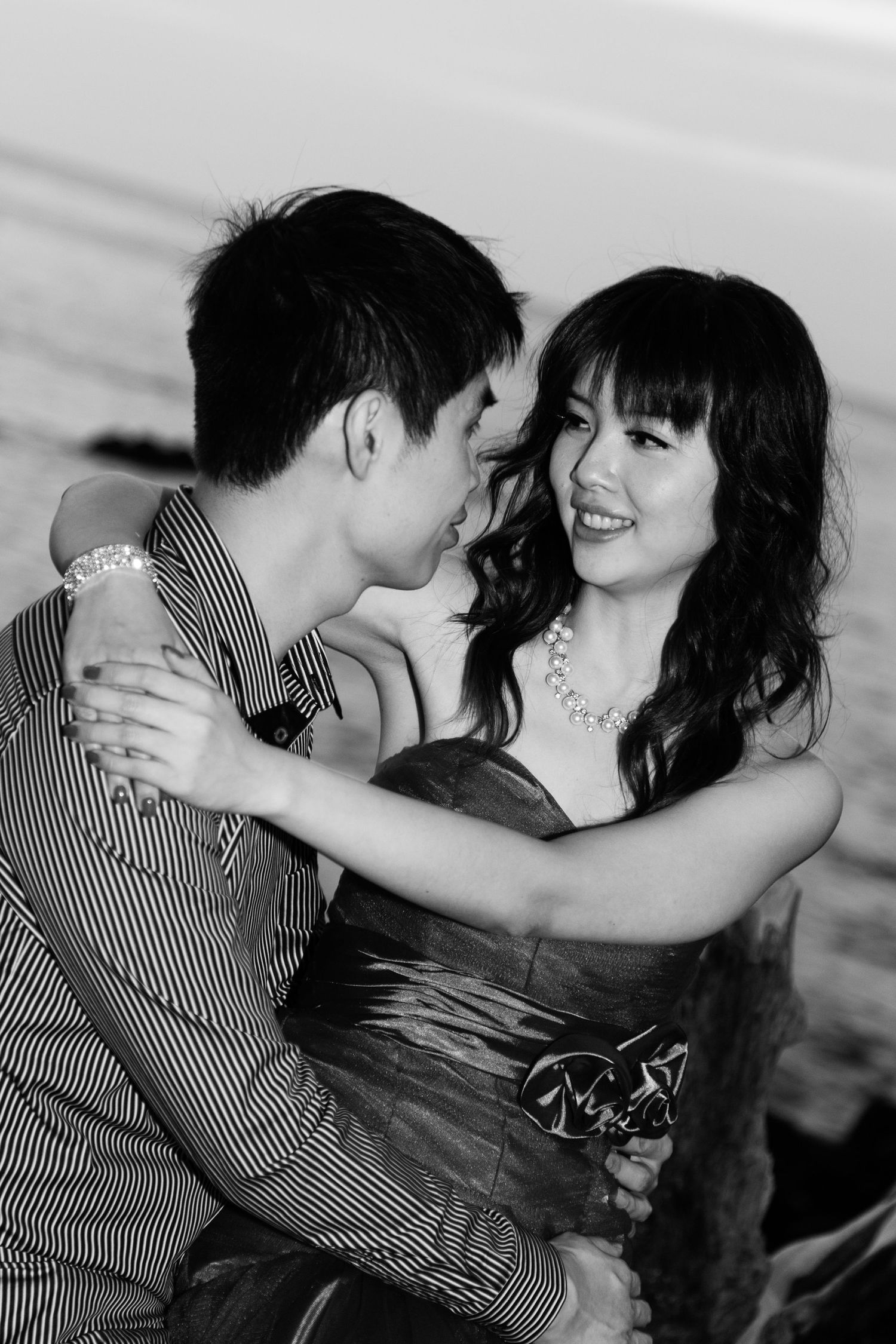 A black and white romantic portrait of a couple during their engagement session at Anaehoomalu Bay beach in the Big Island of Hawaii.