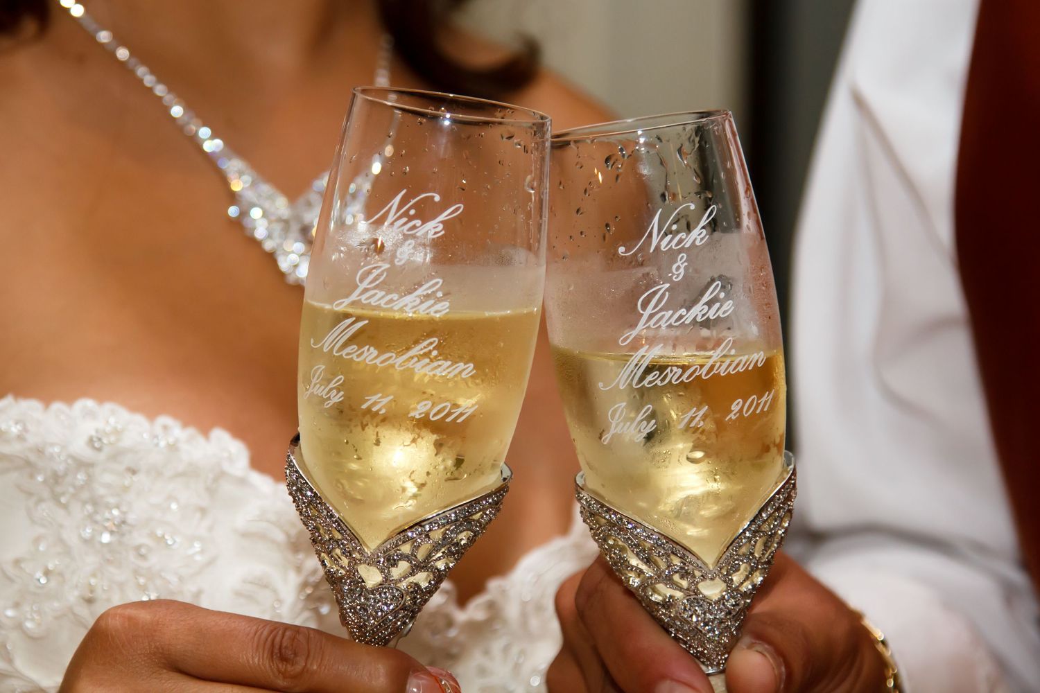 Two elegant champagne flutes with personalized wedding messages clinking in celebration in a wedding at the Outrigger Kona Resort & Spa.