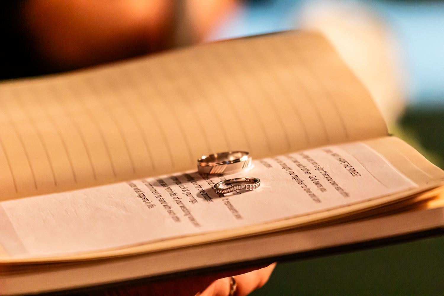 Wedding ring placed on marriage certificate creates artistic silhouette against textured paper.