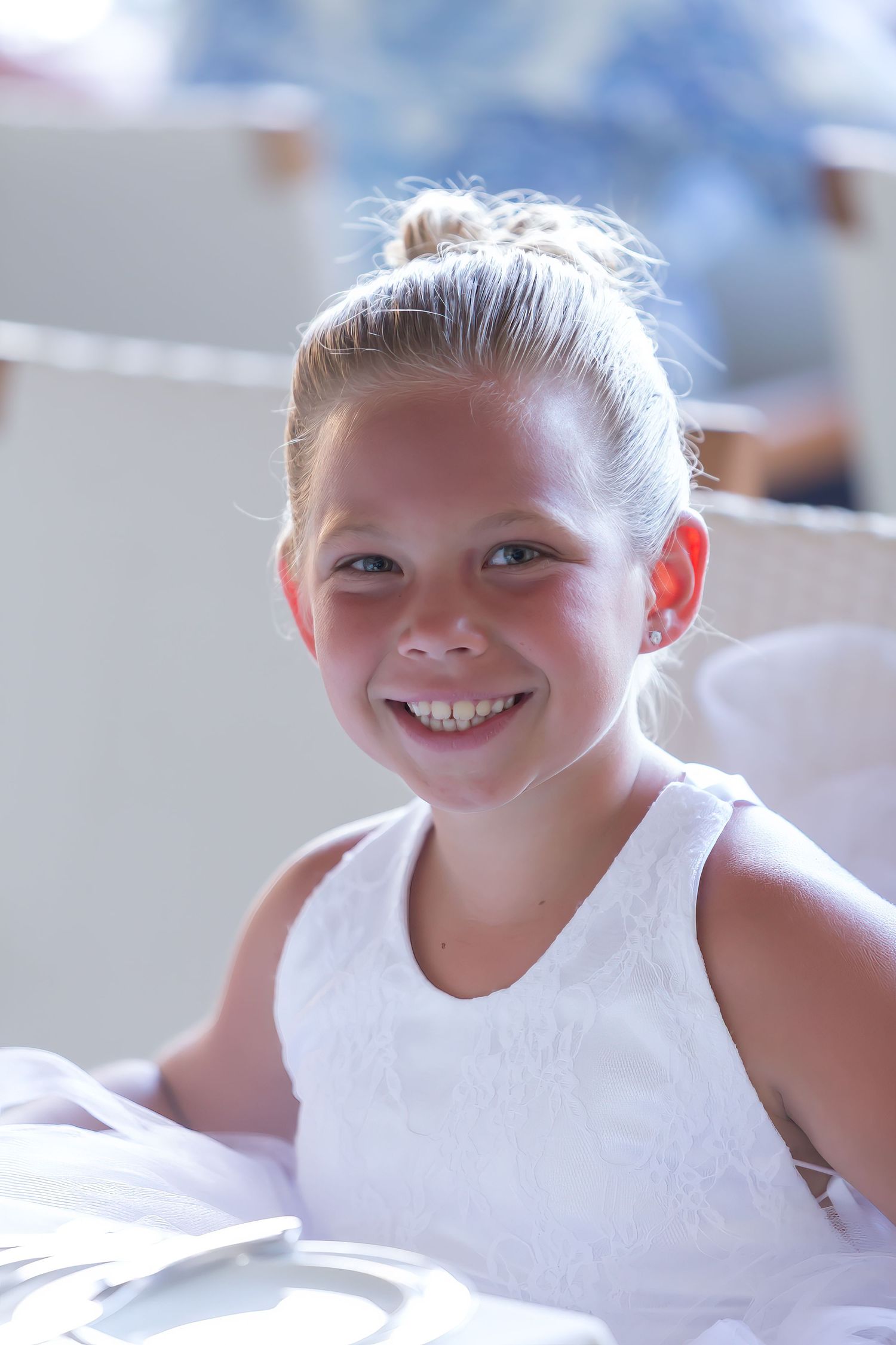 Portrait of 12-year old child in white tank top smiling during a wedding celebration in Princeville, Kauai, Hawaii.