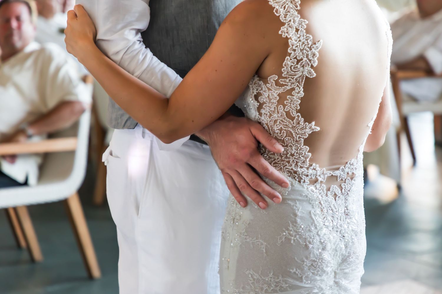 Close-up of wedding couple first dance showing detailed lace back wedding dress design in a wedding in Kauai.
