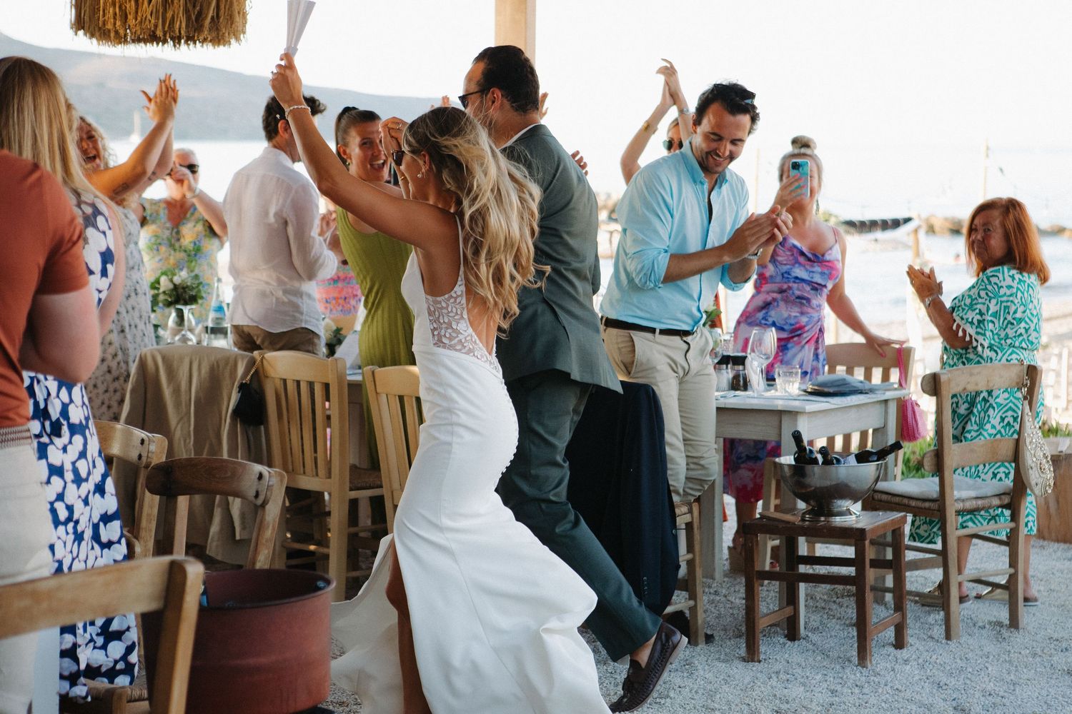 Wedding reception celebration with guests dancing on outdoor patio.