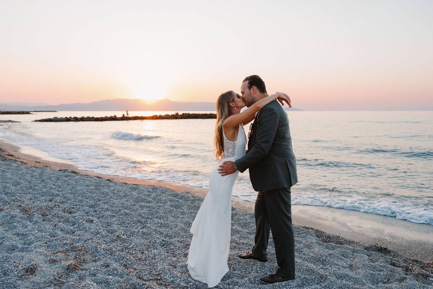 Romantic sunset photos on a beach with waves crashing in the background.