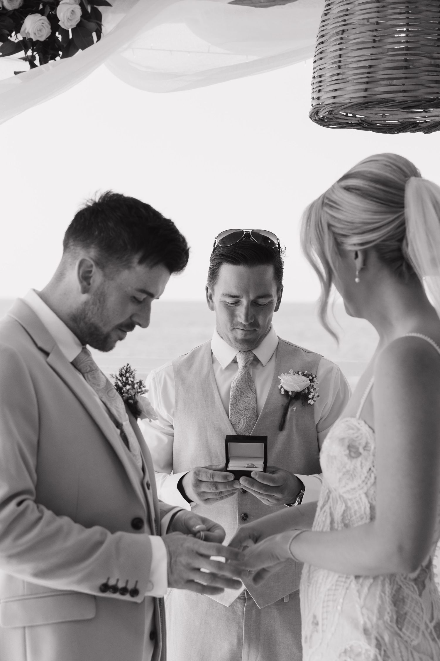 Couple exchanges rings during an intimate wedding ceremony by the beach.