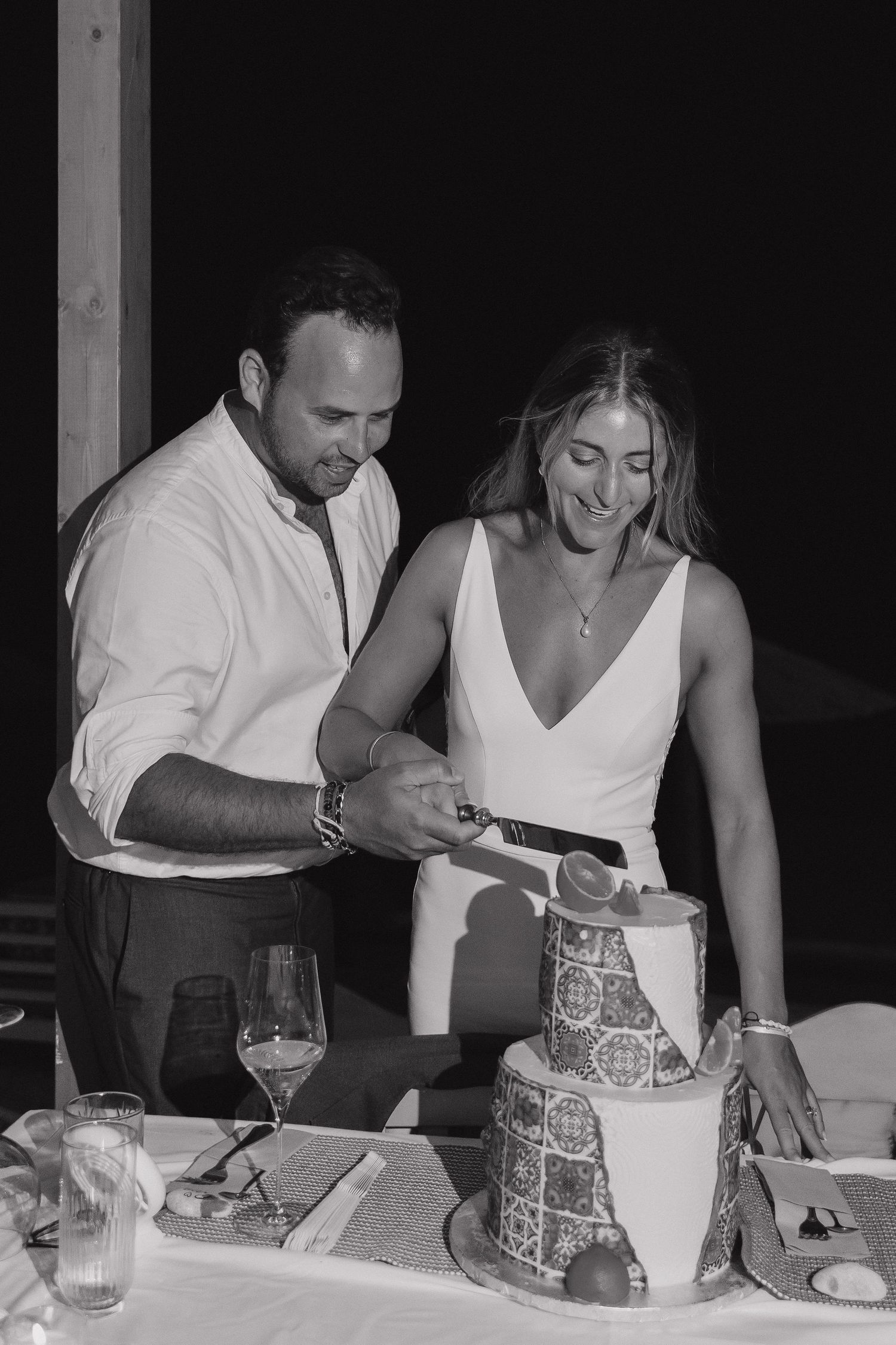 Bride and groom cut their modern grey wedding cake during evening reception.