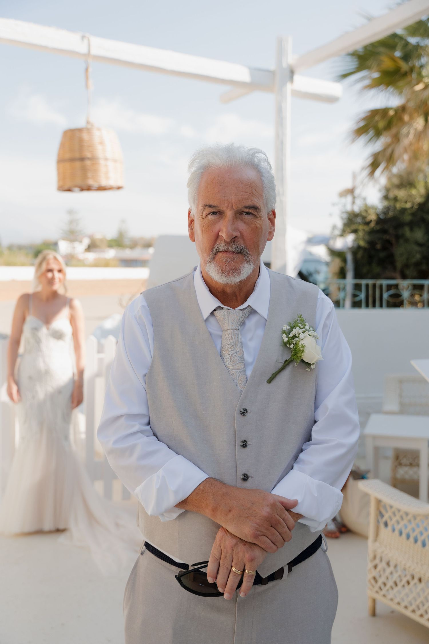 Beachfront wedding venue with hanging rattan pendant lights and ocean views.