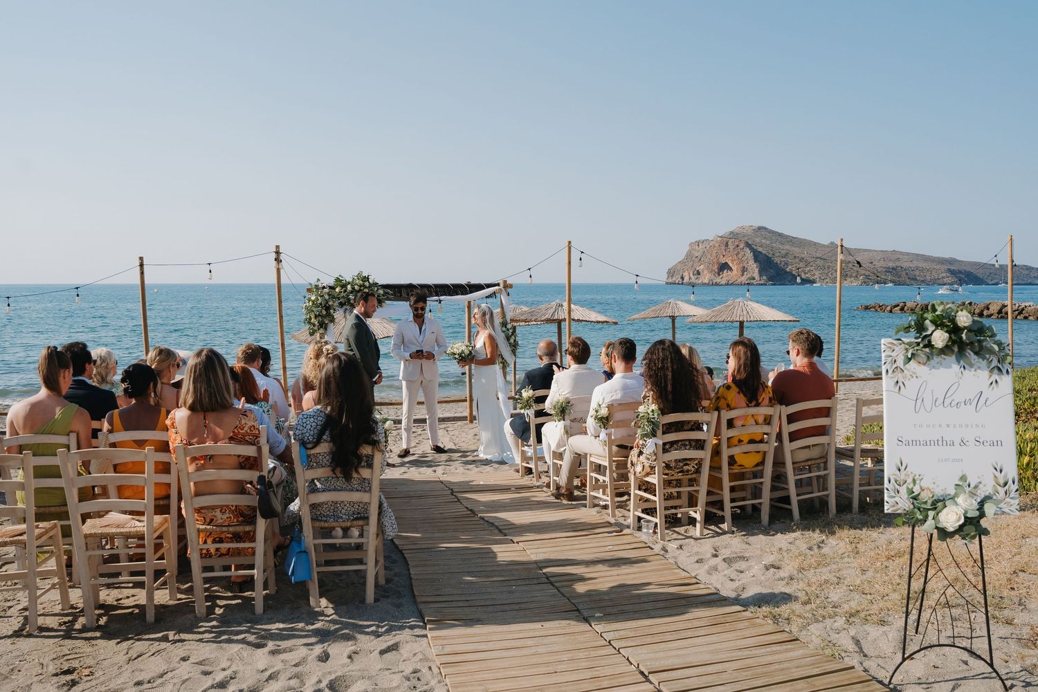 Outdoor beach wedding ceremony setup with wooden chairs and floral arch overlooking Golden Gate Bridge in San Francisco.