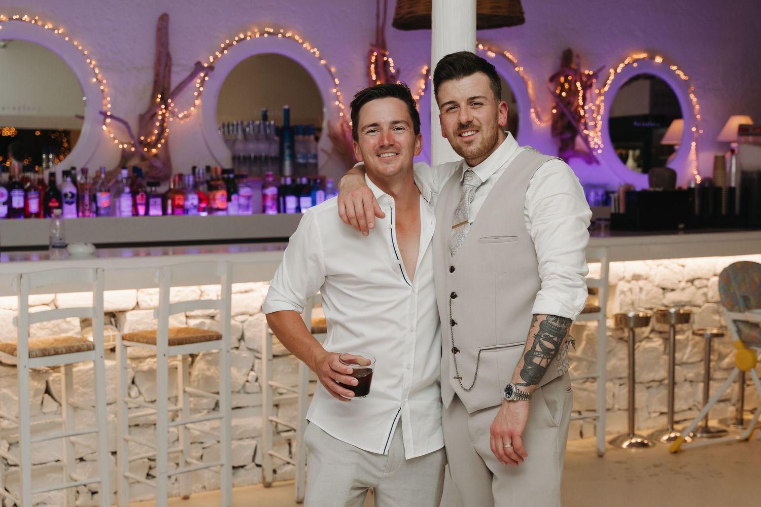 Two guests enjoying themselves at an evening wedding reception with decorative lighting.