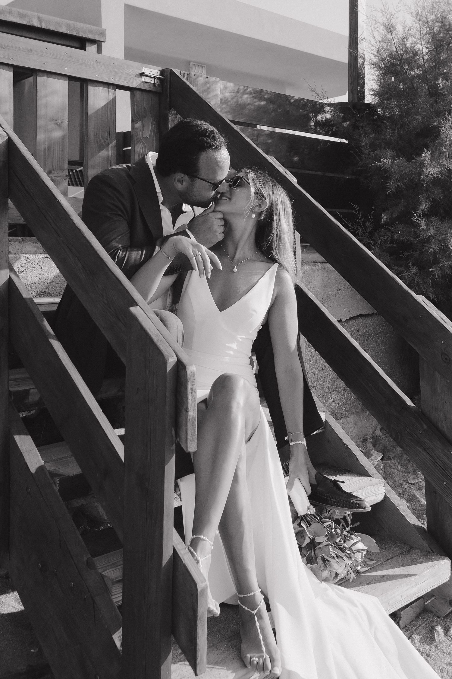Romantic black and white photo on outdoor staircase with elegant white dress.
