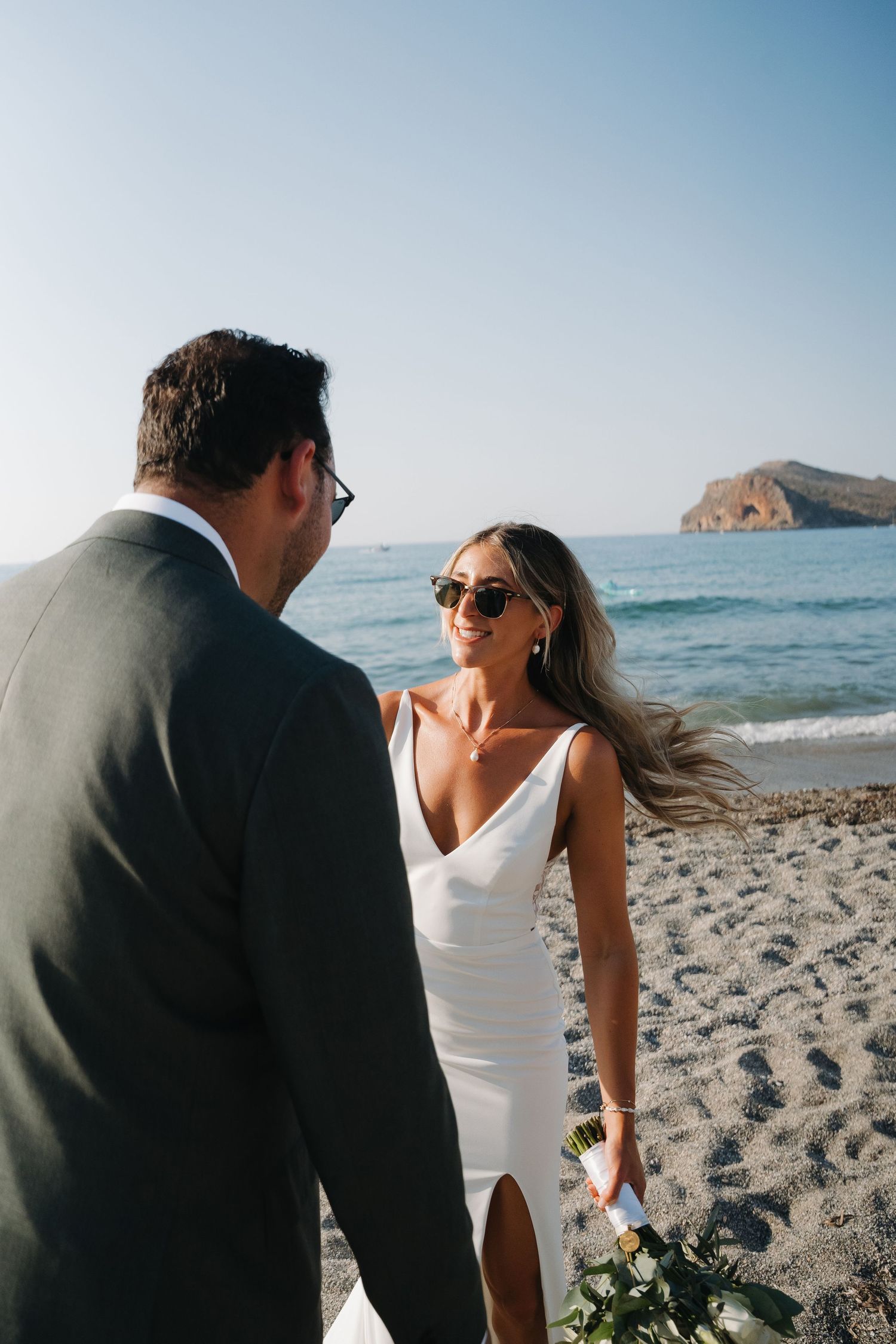 Candid beach wedding photos showing couple enjoying intimate moments by the ocean.