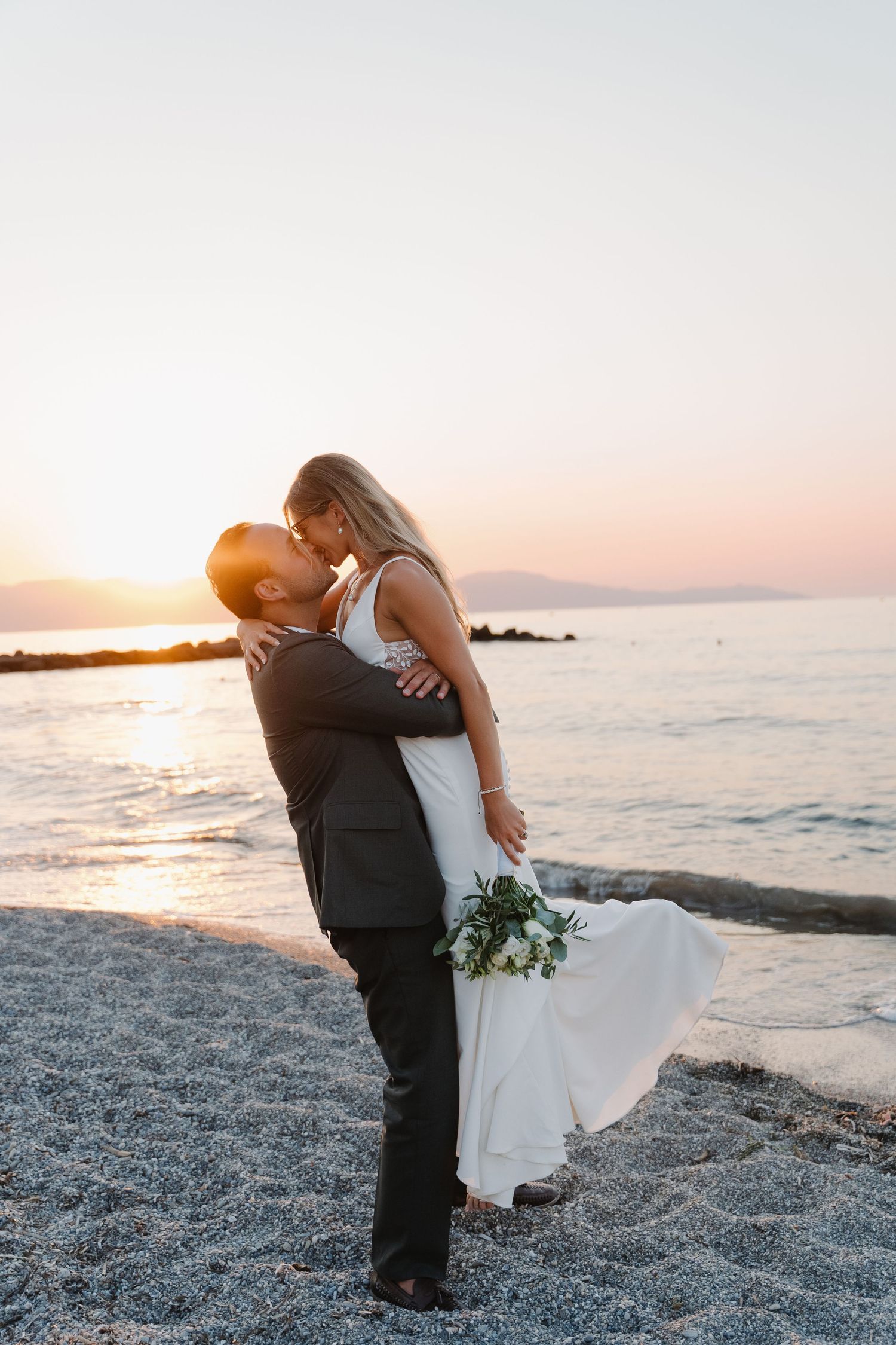 Couple embracing on beach at sunset during romantic wedding photoshoot in Chania, Crete