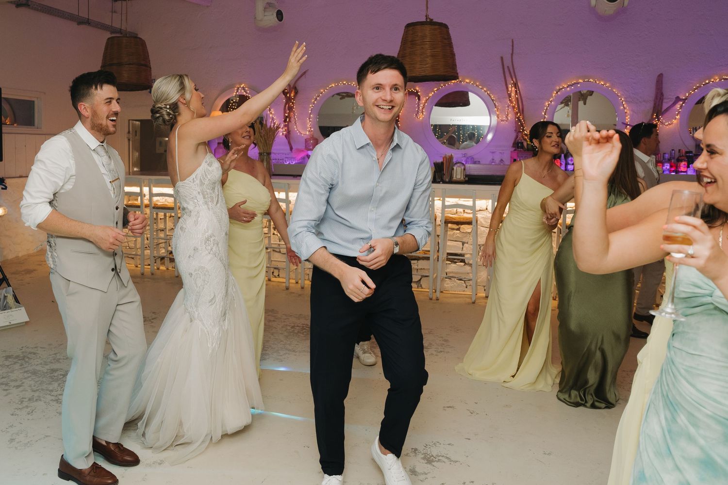 Lively dance party celebrations at beachside wedding reception.