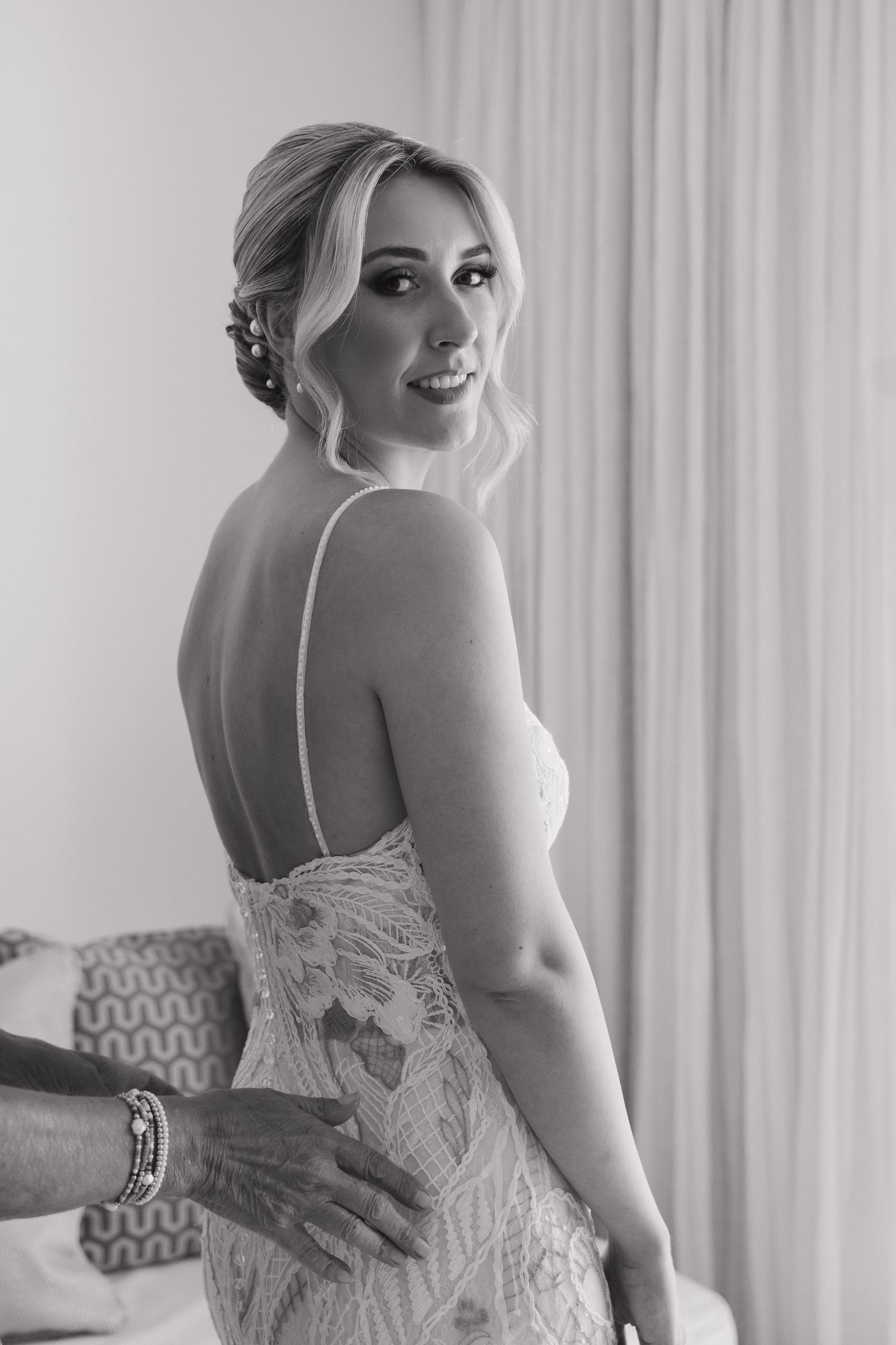 Black and white wedding photo showing intricate back detail of bridal gown.