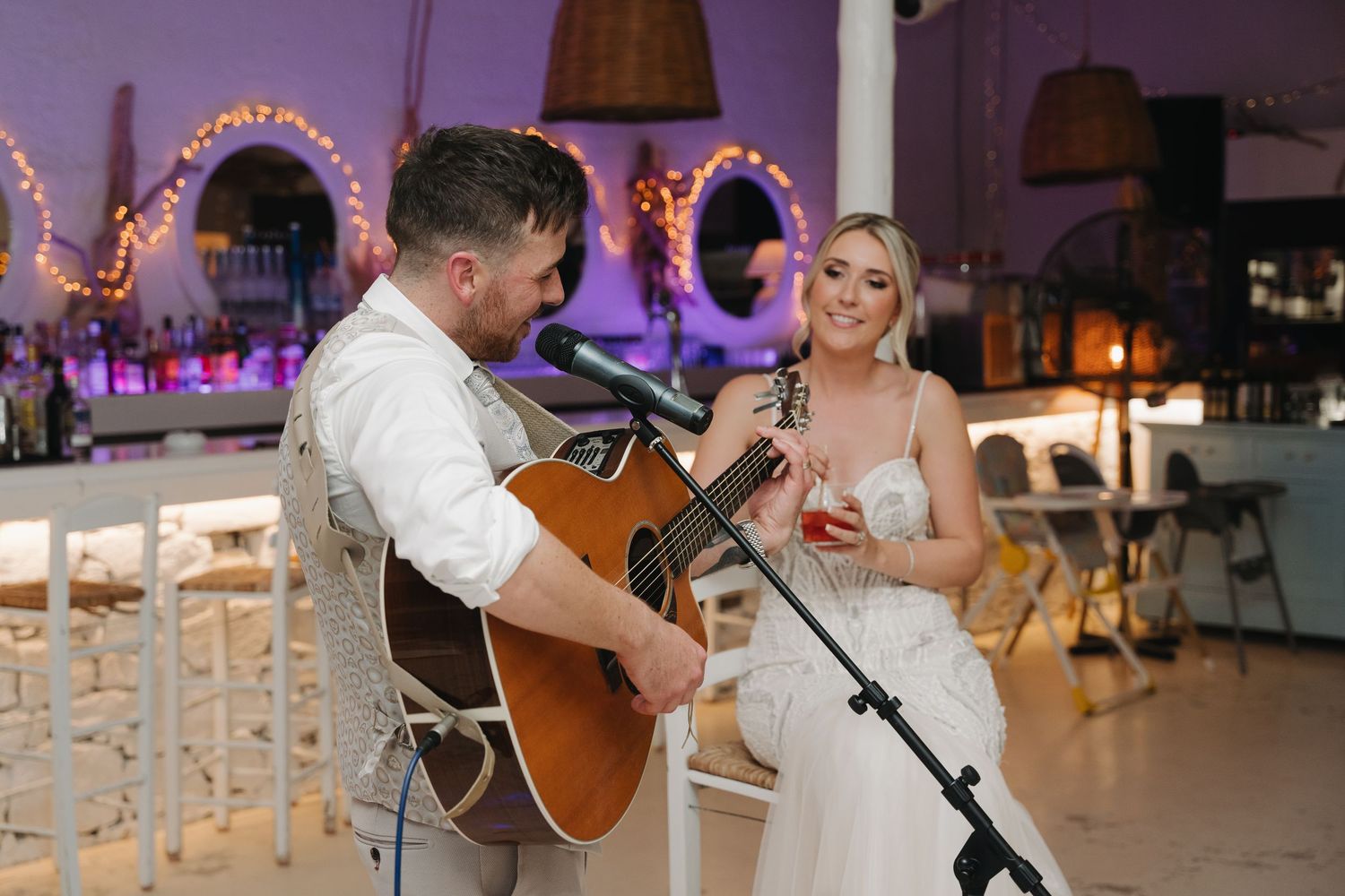 Evening wedding reception with acoustic guitar performance and mood lighting.