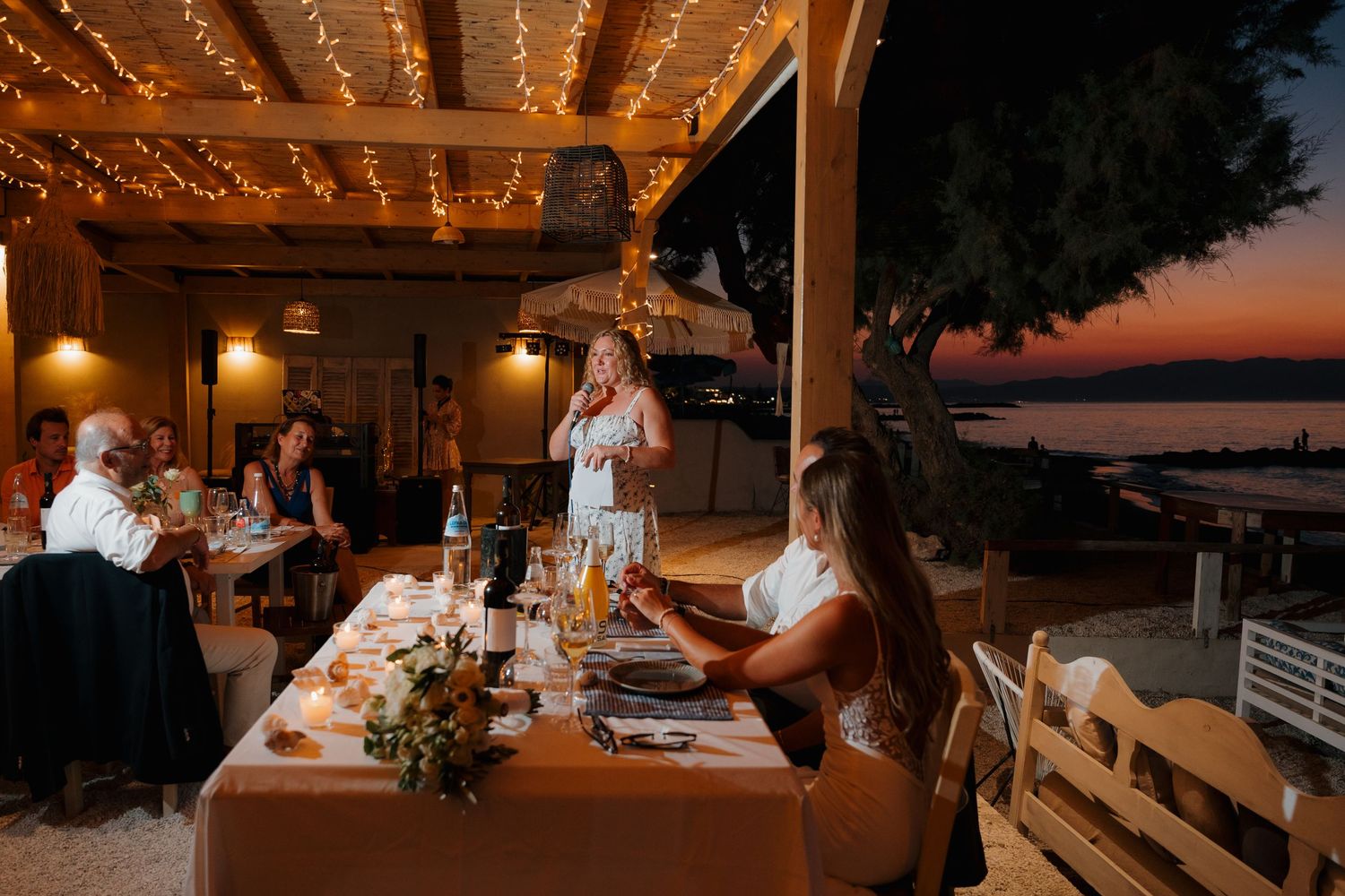 Wedding reception venue decorated with warm string lights creating romantic ambiance at dusk.
