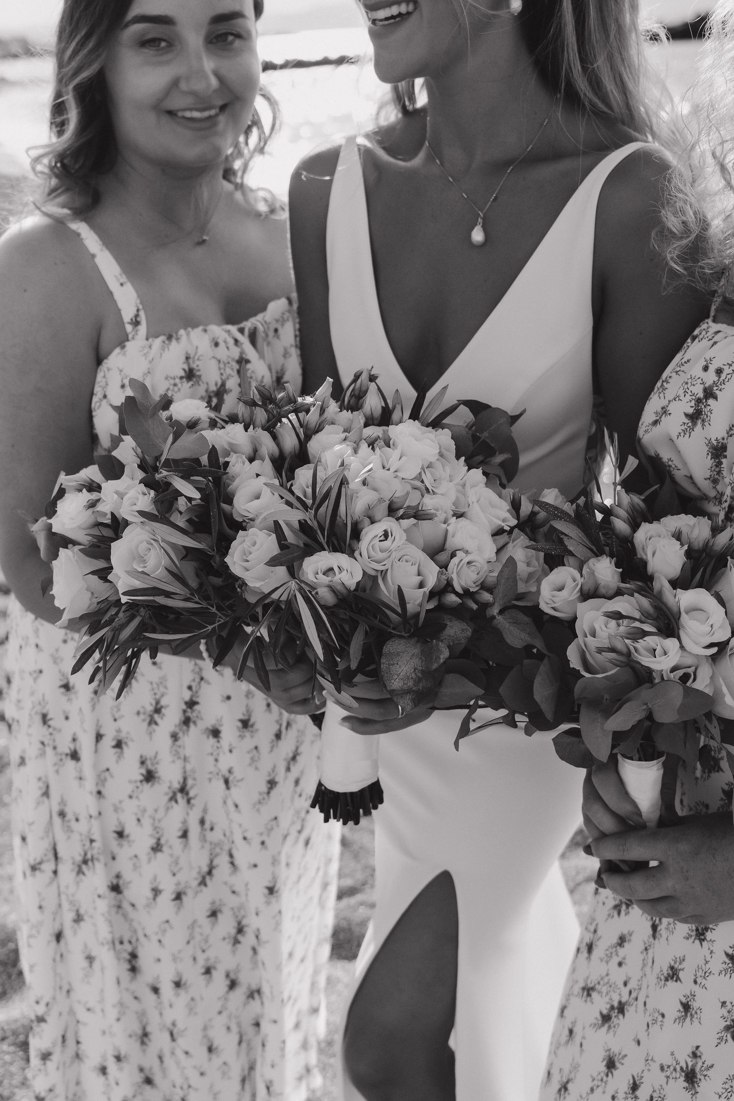 Elegant floral bouquets featuring white roses and delicate blooms at a beach wedding.