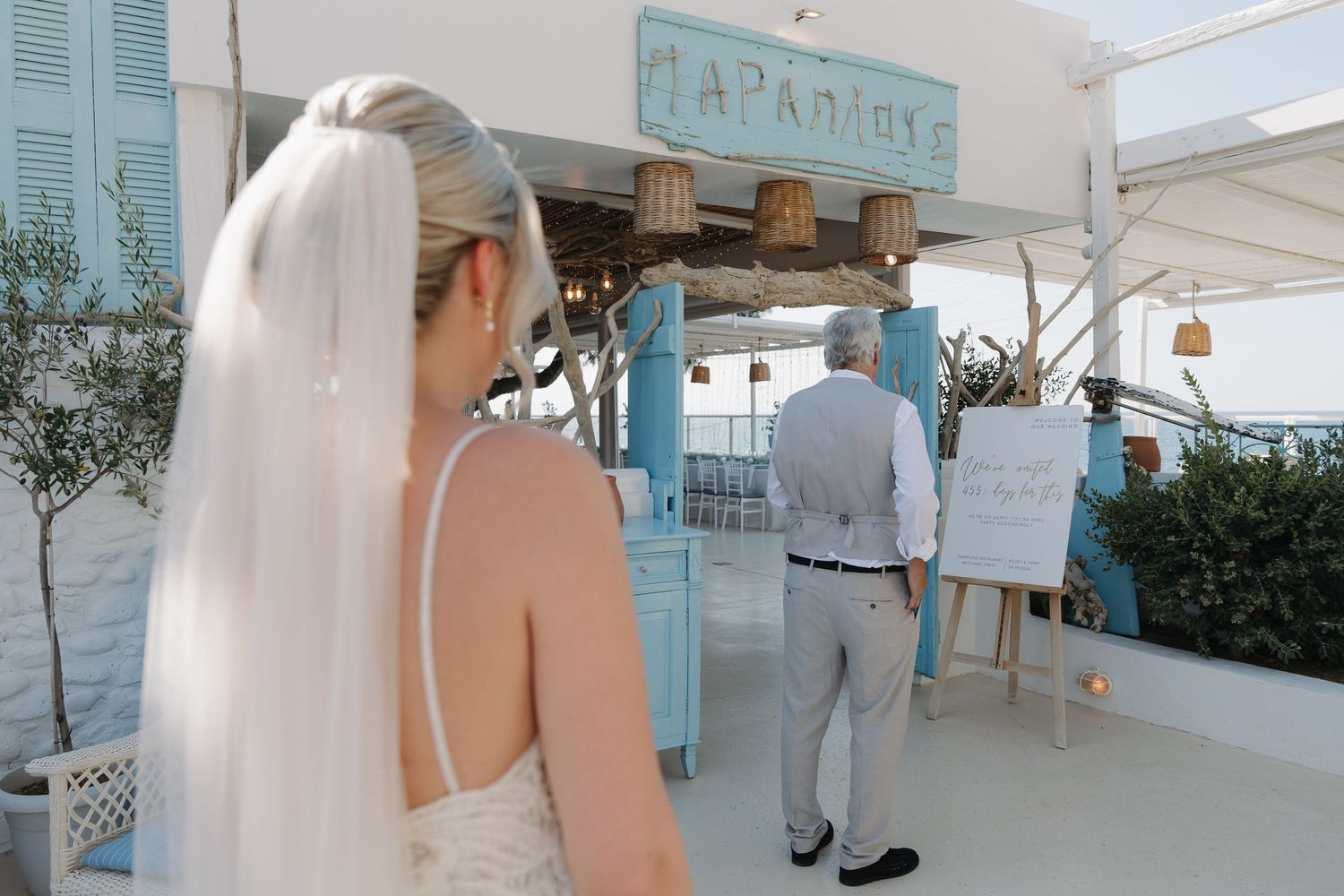 Wedding ceremony setup with bride viewing outdoor coastal venue decorations.