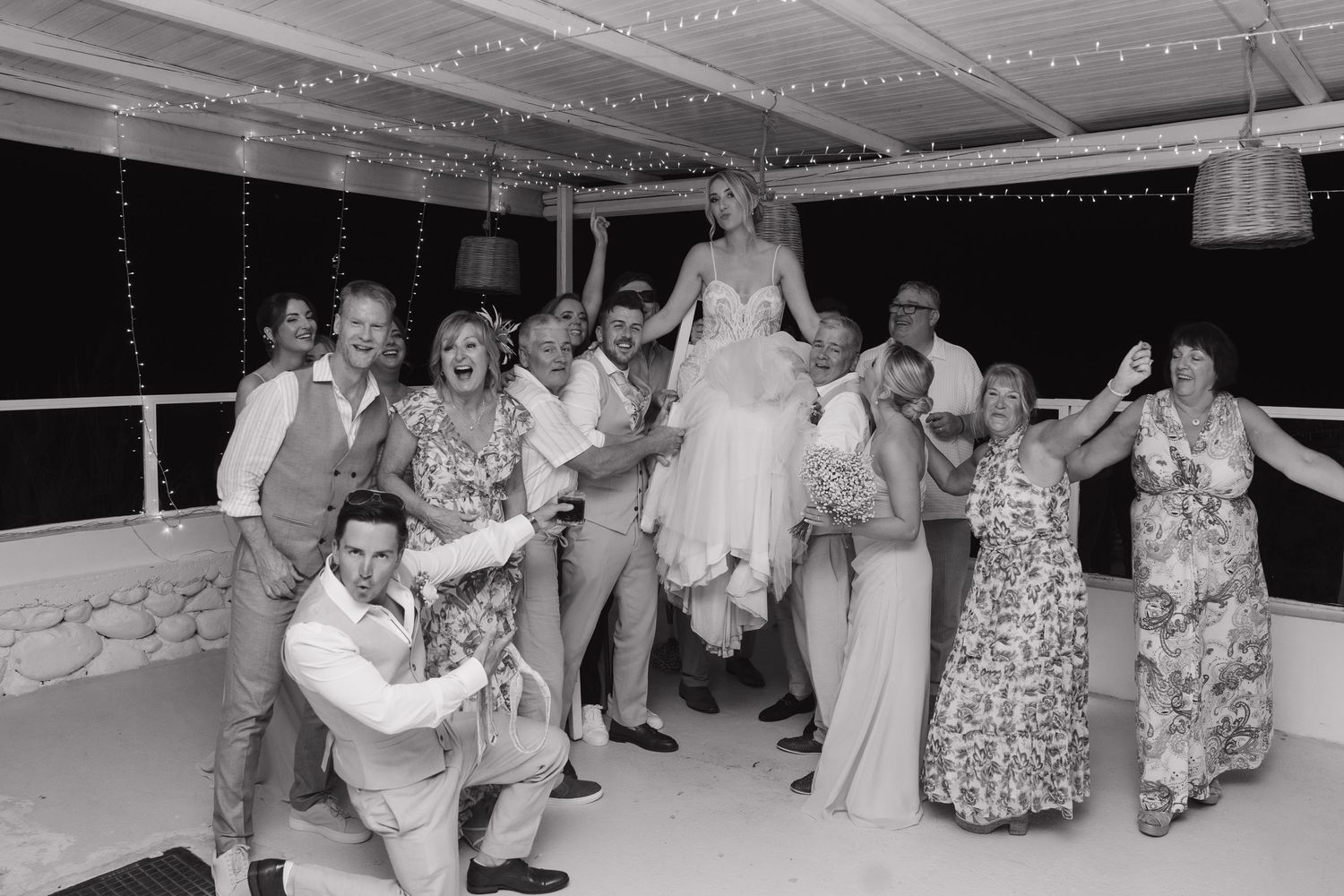 Wedding guests dance energetically during evening reception party.