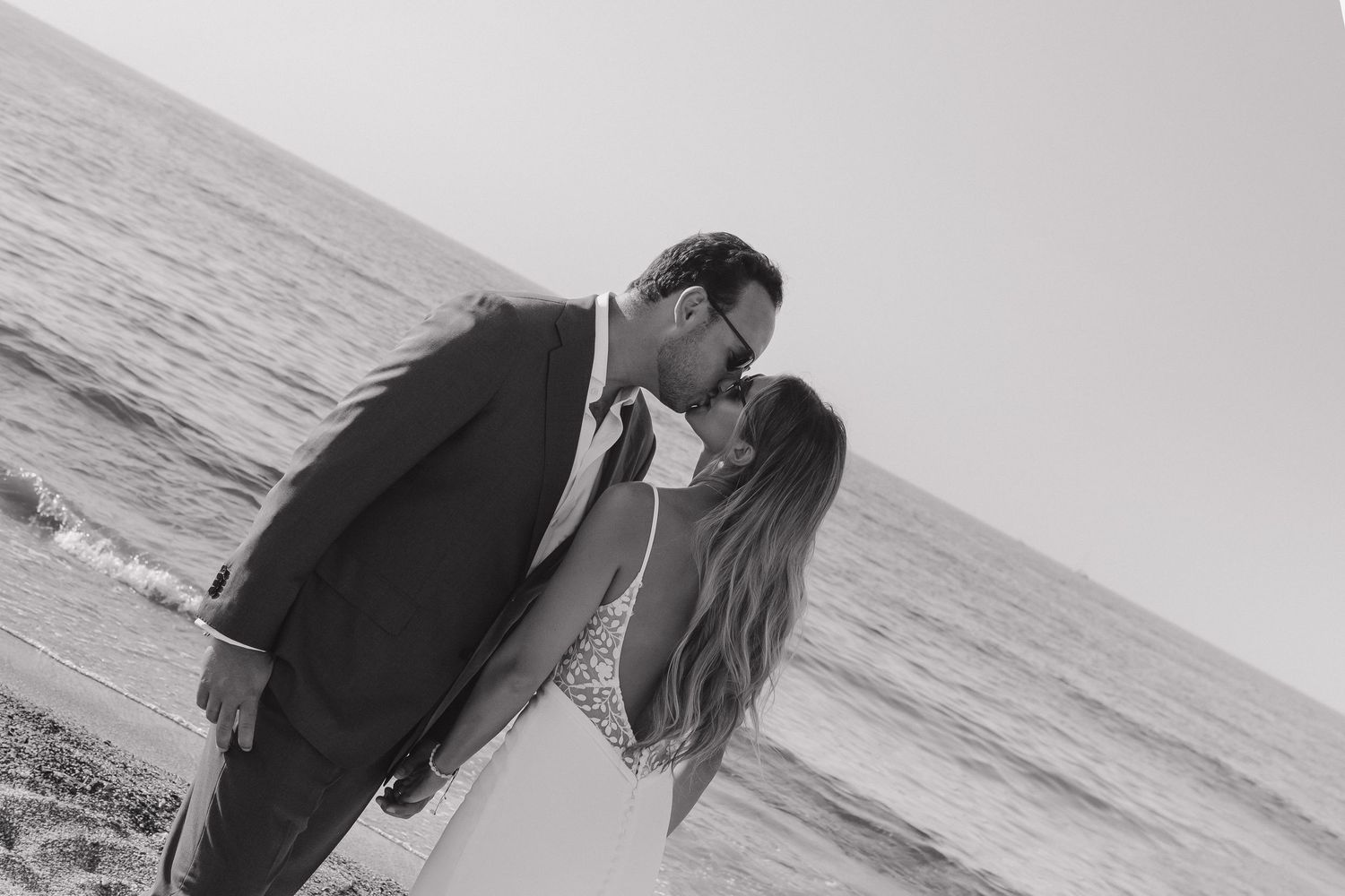 Intimate black and white beach portrait of a couple sharing a romantic moment.