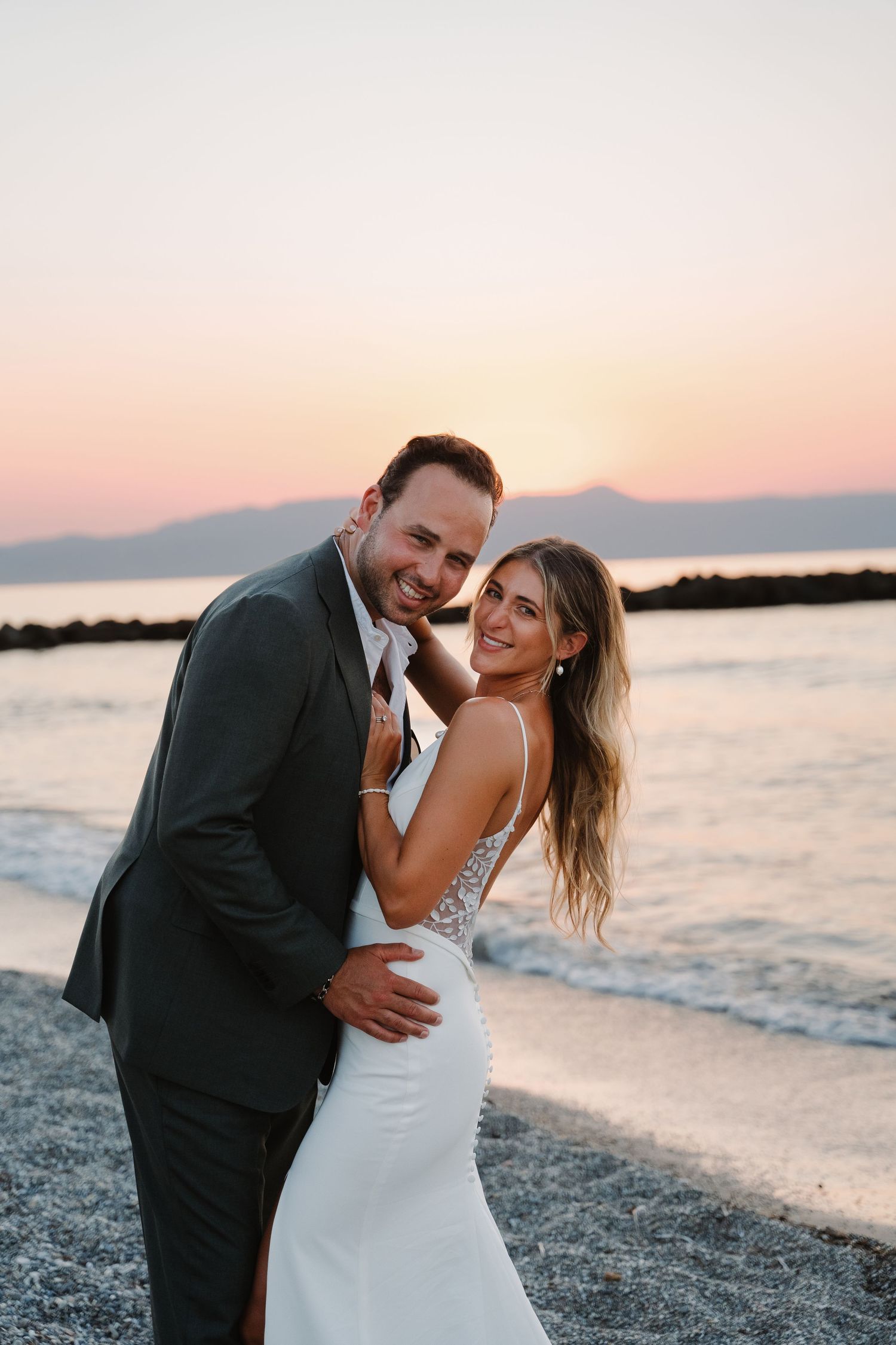 Seaside sunset portrait with mountains in background.