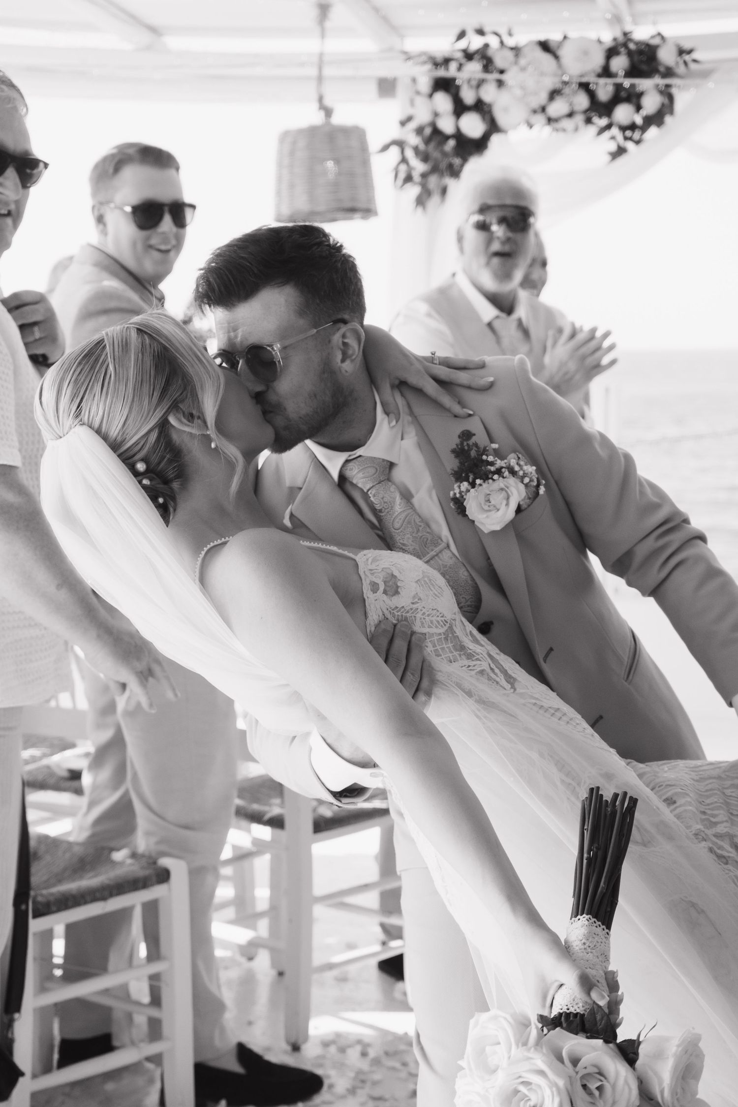 Romantic dip kiss between newlyweds during their first dance at an outdoor reception.