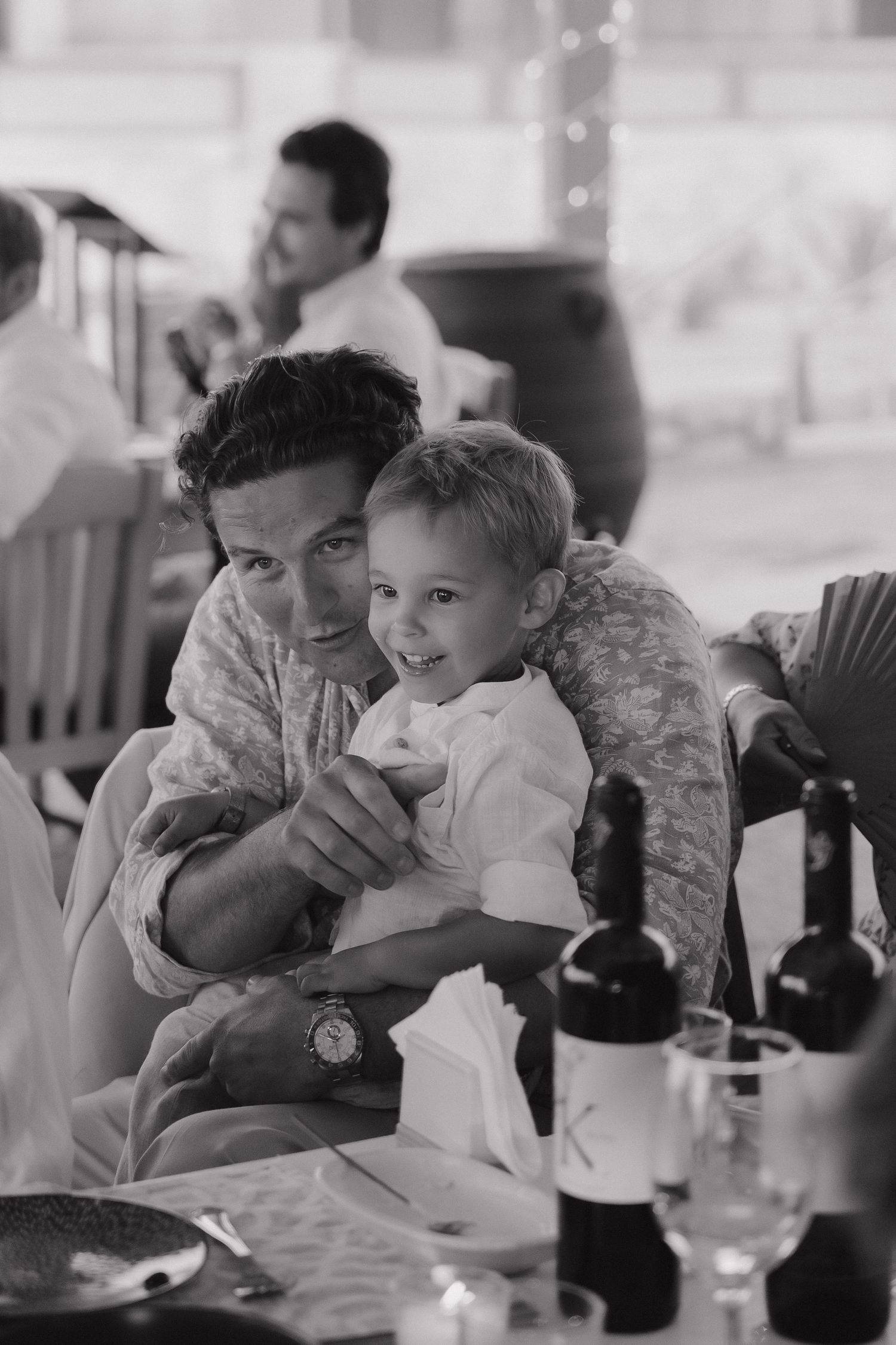 Black and white candid moment of parent and child during reception dinner.