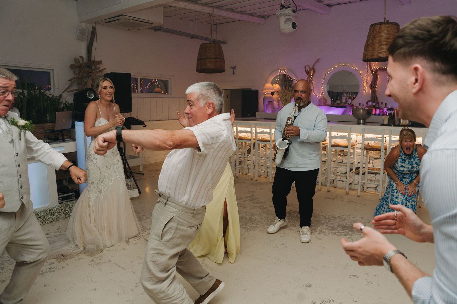 Wedding reception party guests enjoying dance floor celebrations.
