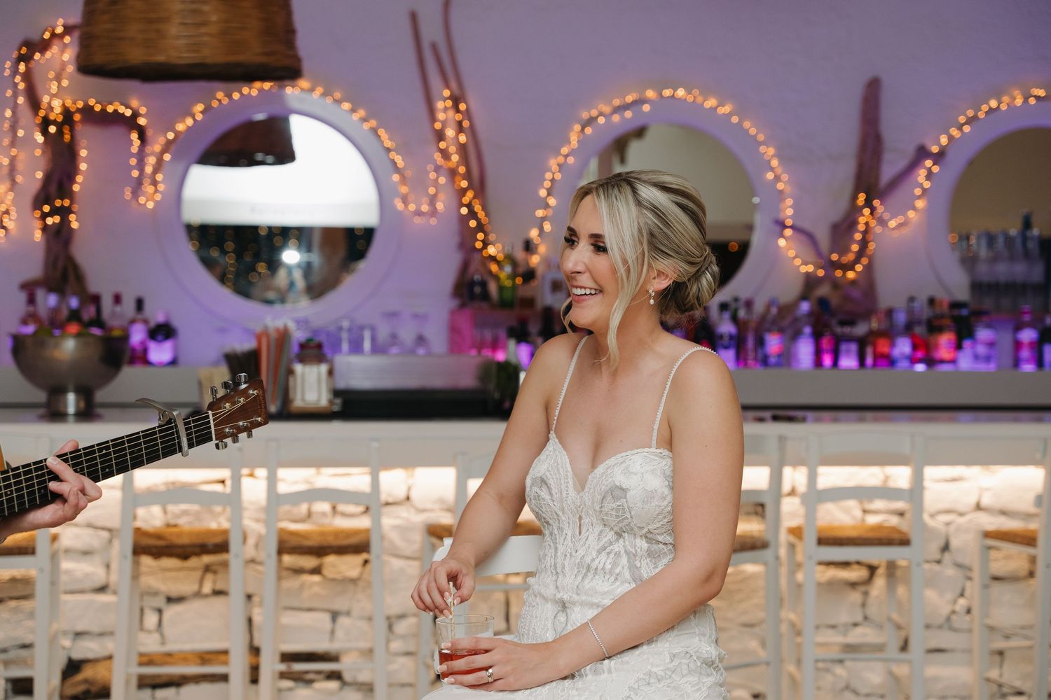 Reception venue decorated with warm string lights and wooden chairs creates welcoming atmosphere.