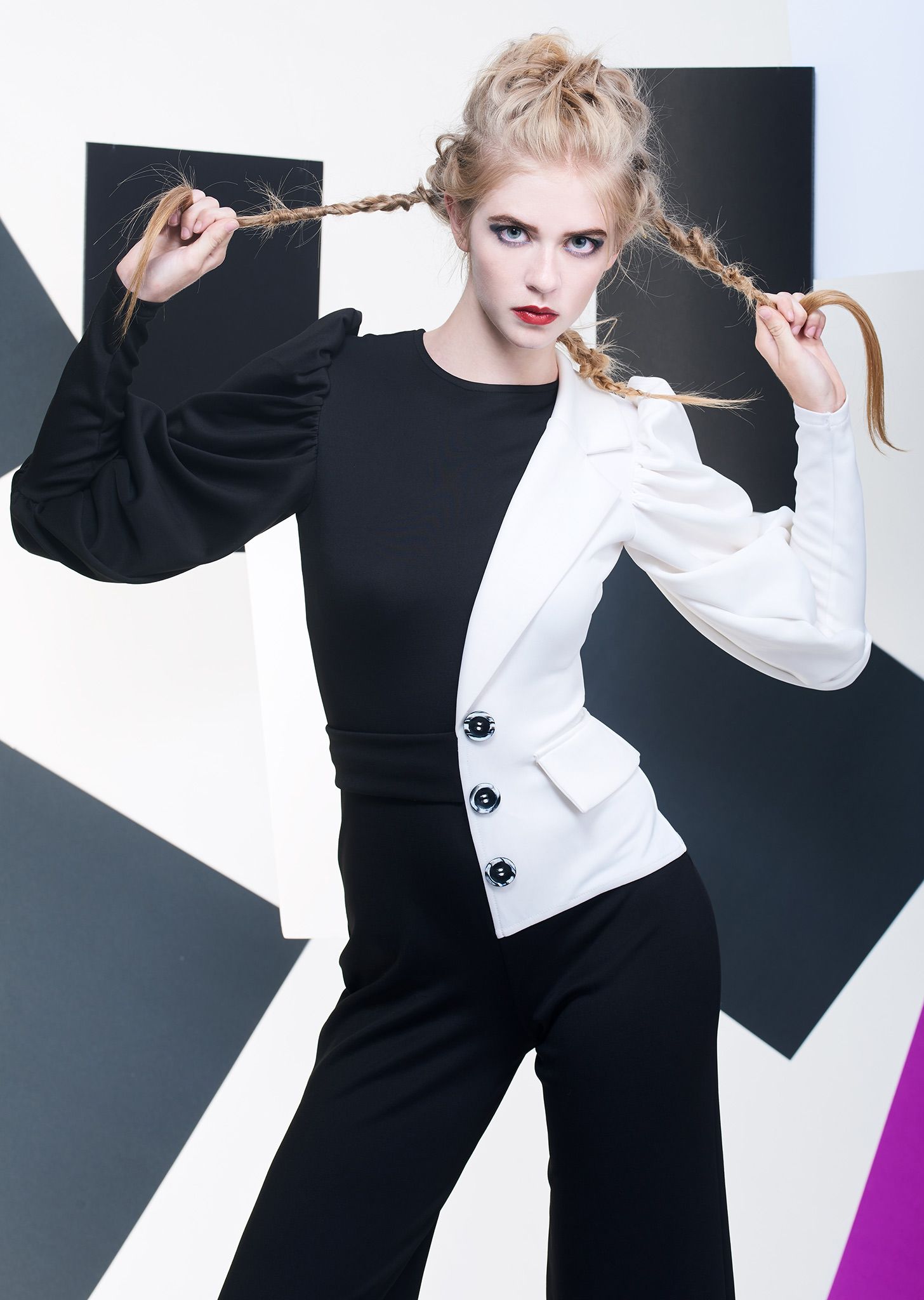 High fashion portrait featuring black and white split design outfit with dramatic styling.