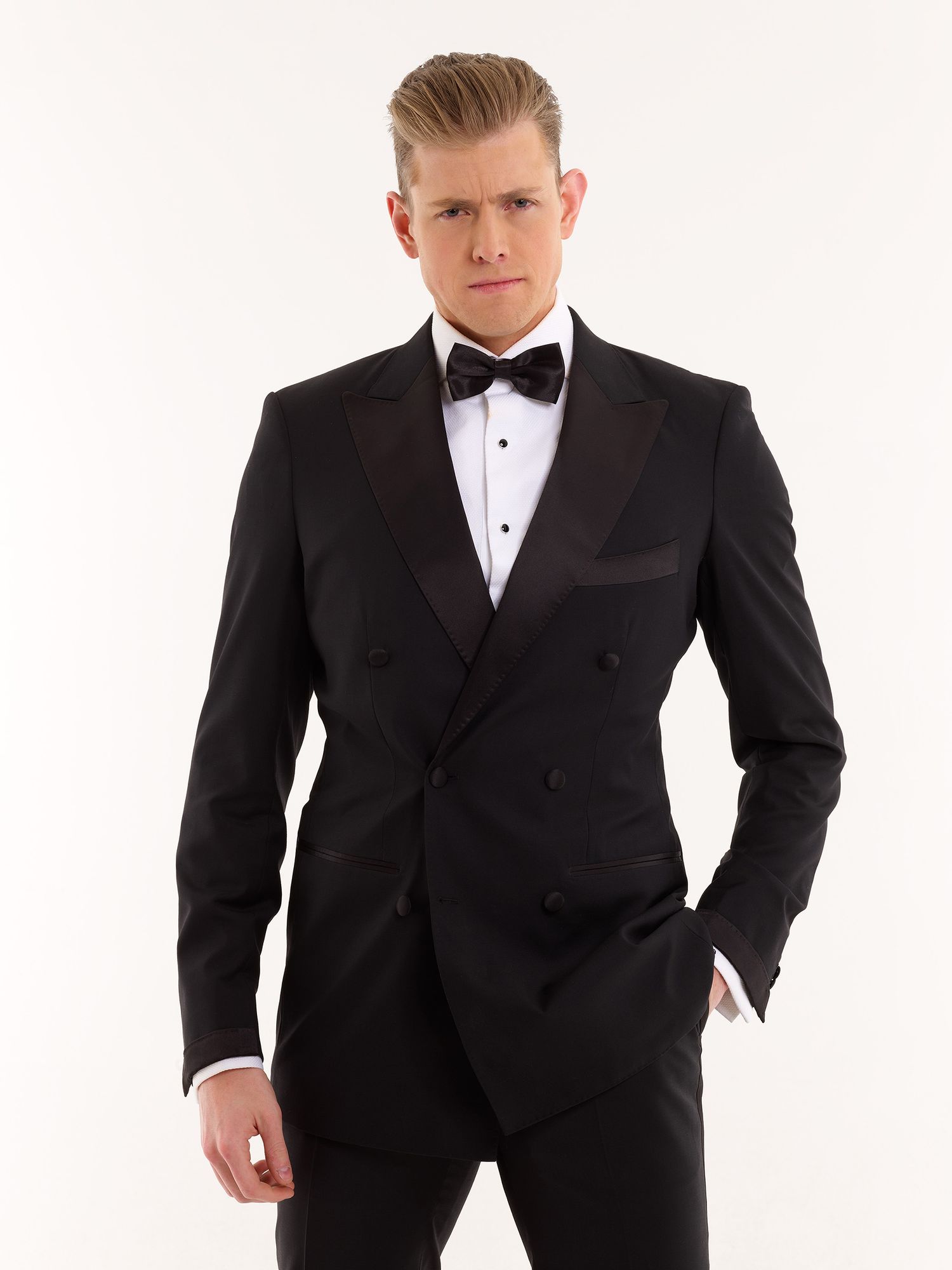 A stylish double-breasted tuxedo paired with a crisp white shirt and black bow tie against a white background.