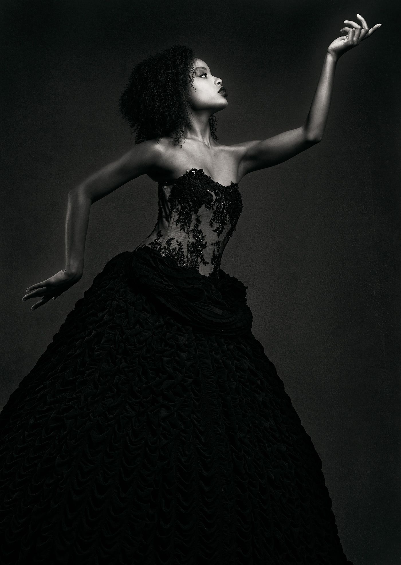 Elegant black dress-clad figure in dramatic dance poses captured in high-contrast black and white artistic photography series.